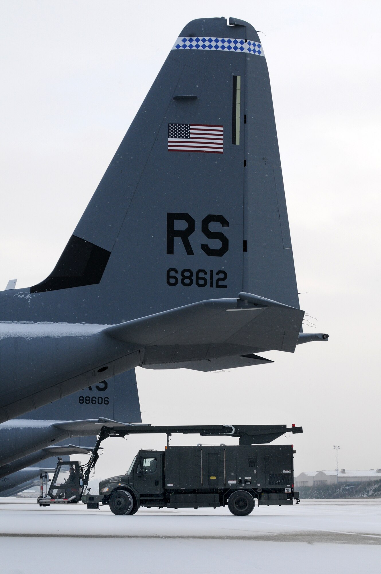 U.S. Air Force personnel from the 86th Aircraft Maintenance Squadron prepare to de-ice a C-130J at Ramstein Air Base, Germany, January 7, 2010. Aircraft deicing is a process in which liquid solutions are sprayed onto an aircraft to defrost ice and prevent future precipitation from freezing. (U.S. Air Force photo by Airman 1st Class Brea Miller)