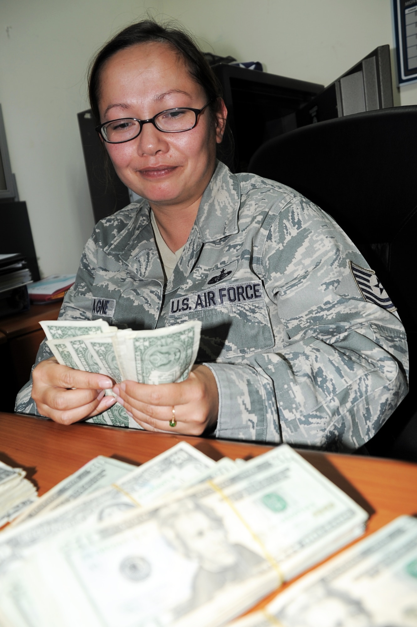 Tech. Sgt. Caroline M. Champagne, from the 380th Expeditionary Force Support Squadron at a non-disclosed base in Southwest Asia, counts cash used for non-appropriated fund morale and welfare activities in her deployed office Jan. 8, 2009. Sergeant Champagne, a 15-year Air Force veteran, is the non-appropriated fund, or NAF, custodian for the 380th Expeditionary Force Support Squadron at a non-disclosed base here. She is deployed from the 62nd Force Support Squadron at McChord Air Force Base, Wash. (U.S. Air Force Photo/Tech. Sgt. Scott T. Sturkol/Released)