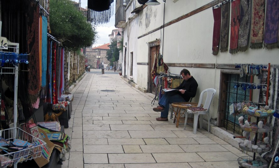 A local store owner sits on the side of a path in the Old Antalya district of Antalya. The district is lined with boutique hotels, specialty stores, restaurants, bars, Turkish baths and lounges that are popular with tourists and locals alike. (U.S. Air Force photo/Senior Sara Csurilla)