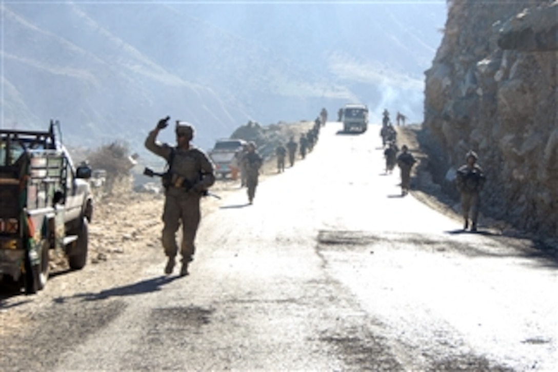 A U.S. Army soldier from Apache troop, 3rd Squadron, 61st Cavalry Regiment, 4th Brigade Combat Team, 4th Infantry Division signals the location of a rally point to the soldiers behind him while on patrol in Naray, Afghanistan, on Jan. 4, 2010.  