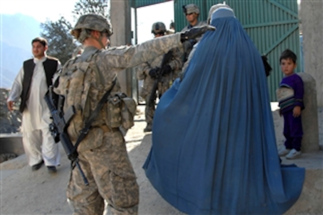 U.S. Army Spc. Stacie Triick searches an Afghan woman entering a health clinic in Naray, Afghanistan, Jan. 4, 2010. U.S. soldiers are conducting classes for Afghan women on pregnancy and feminine hygiene. Trilick is a member of a female engagement team out of Forward Operating Base Bostick.