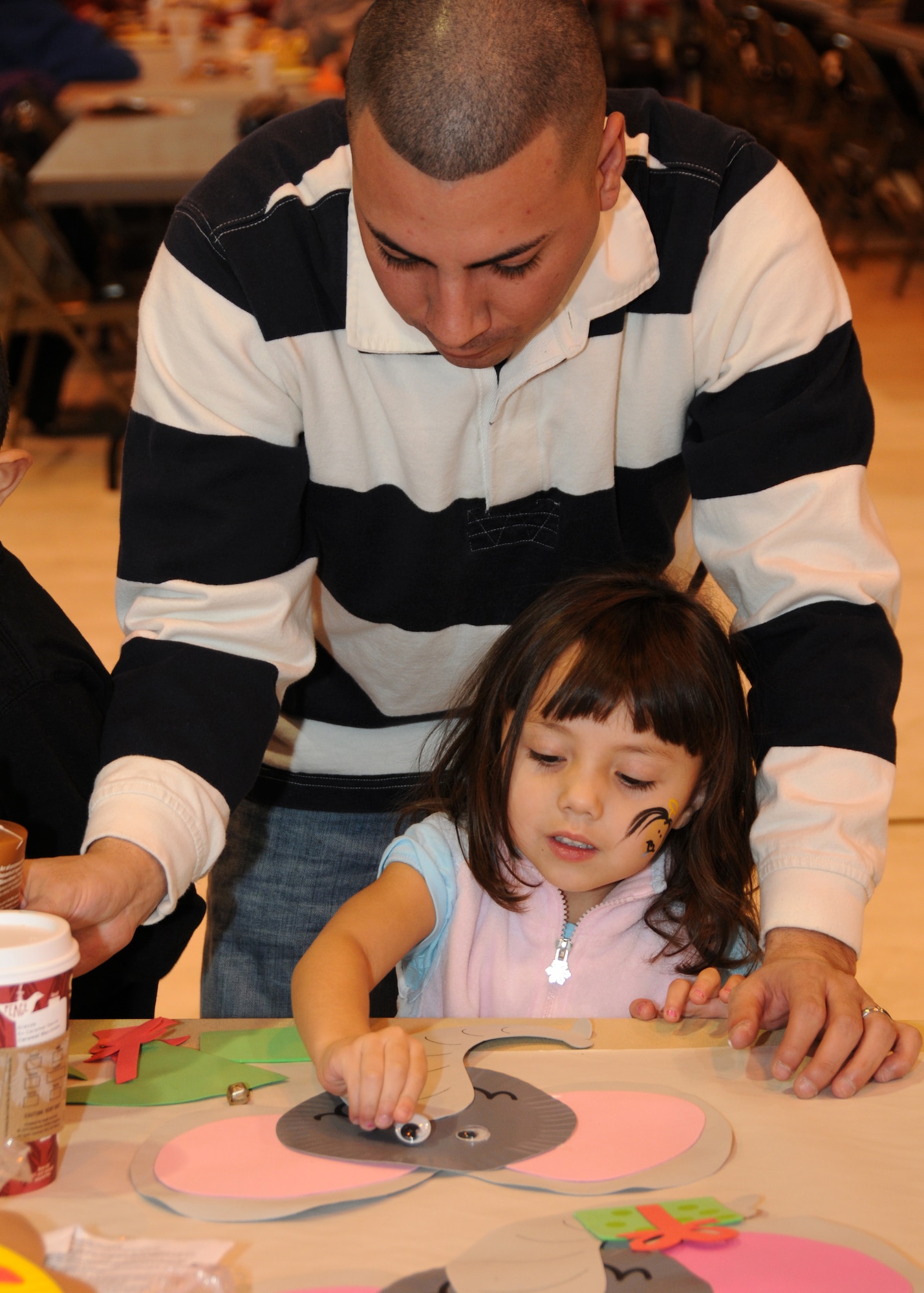 Tech. Sgt. Anthony Valdez, 151st Communications Flight, and his daughter Evangelina, make crafts during the Utah Air National Guard?s annual Children's Christmas Party on December 12. The event included a variety of children?s activities, including face painting, crafts and performing clowns. U.S. Air Force Photo by: Staff Sgt. Emily Monson (RELEASED)