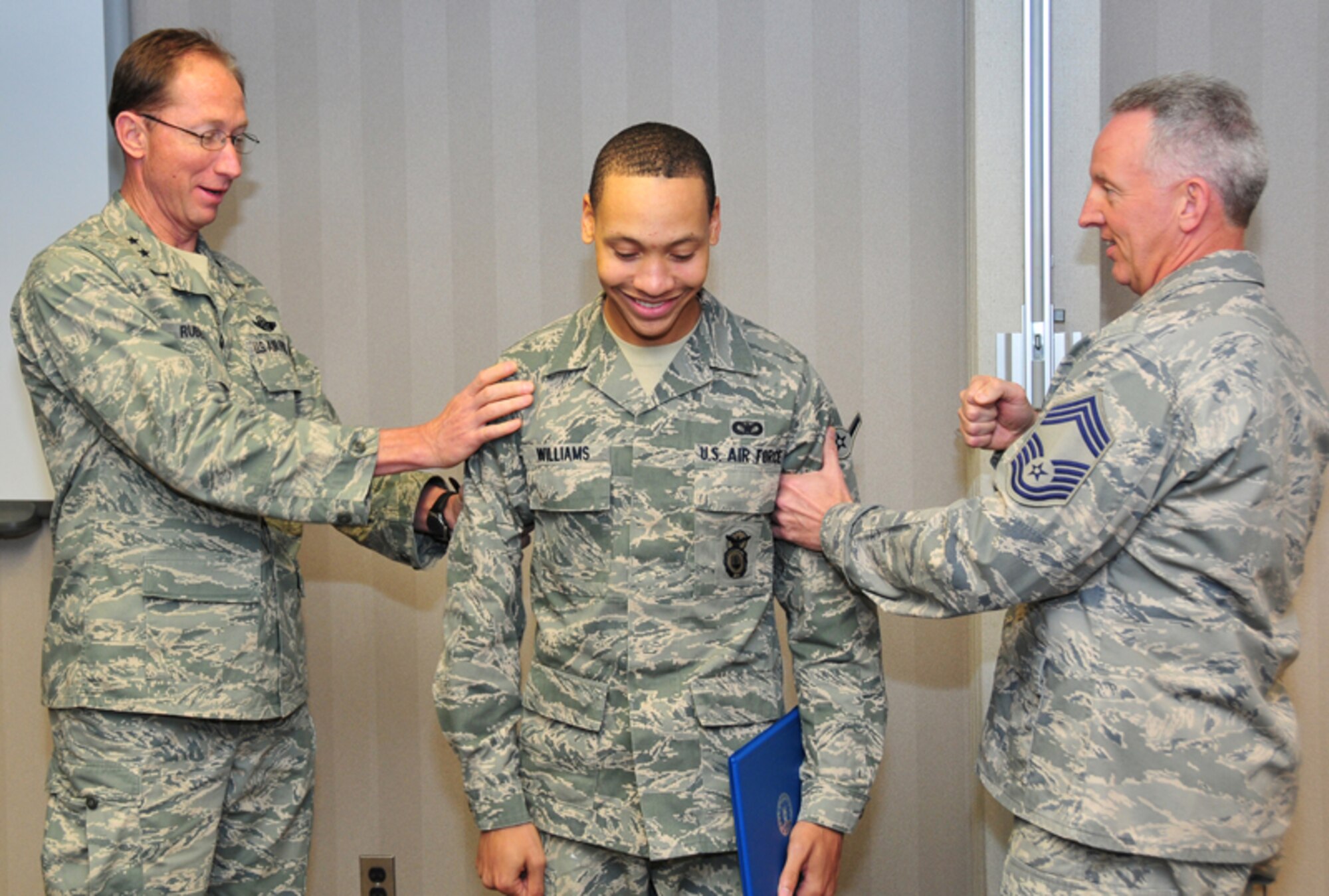 Airman David H. Williams, security forces apprentice, 94th Security Forces Squadron, receives the ceremonial “tagging of stripes” from 22nd Air Force Commander Maj. Gen. James T. Rubeor and Command Chief Master Sgt. Steven M. Larwood during his promotion Jan. 9. General Rubeor and Chief Larwood visited the Airmen of the 94th Airlift Wing during the Unit Training Assembly as part of their commitment to visit every unit in the 22nd Air Force and ensure everyone has the necessary facilities and training they need to complete their mission. (U.S. Air Force photo: Tech. Sgt. Nicholas Ontiveros)