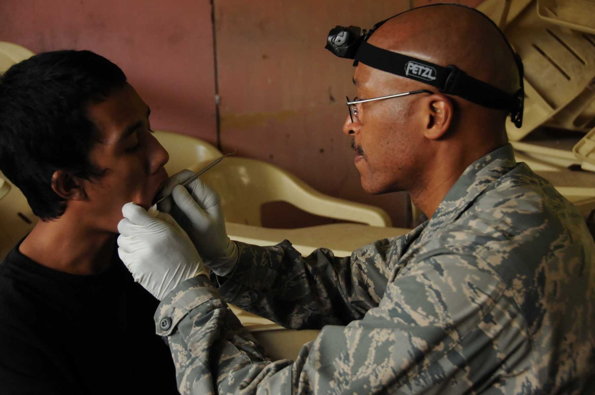 JOLO, Philippines -- U.S. Air Force Lt. Col. Arnold Stocker, assigned to Joint Special Operations Task Force-Philippines, examines the mouth of a young boy Nov. 28, 2009 during a Medical Civic Action Project (MEDCAP). Colonel Stocker was deployed from the 920th Aeromedical Staging Squadron, Patrick Air Force Base, Fla. Led by the Armed Forces of the Philippines, JSOTF-P members assisted with the treatment of more than 200 patients for dental care, medical check-ups, and distributed medications and toiletries. (U.S. Navy photo/Lt.j.g. Theresa Donnelly)