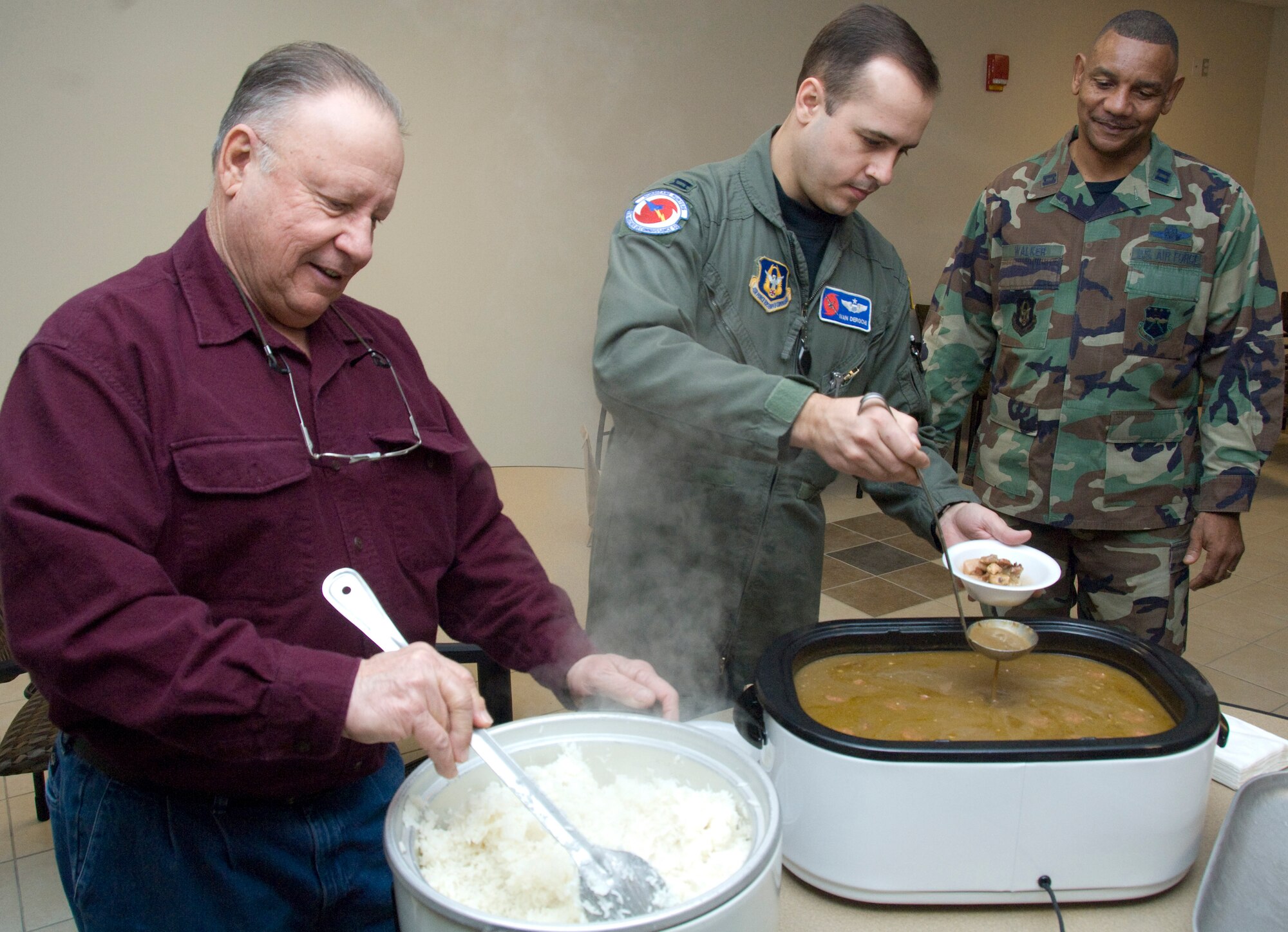 Capt. Ivan Deroche, 53rd Weather Reconnaissance Squadron pilot, serves up a bowl of gumbo to Capt. Dennis Walker, 403rd Maintenance Squadron, at the 2010 Gumbo Cook-off during the Saturday Unit Training Assembly. Captain Deroche and his father, Donald Deroche (left), teamed up to win first place for the competition. Proceeds raised from the cook-off went toward the 403rd Wing Key Family Member Program, which is made up of volunteers whose goal is to ensure well-being of family and friends of activated reservists by providing them with information, communication and resources.