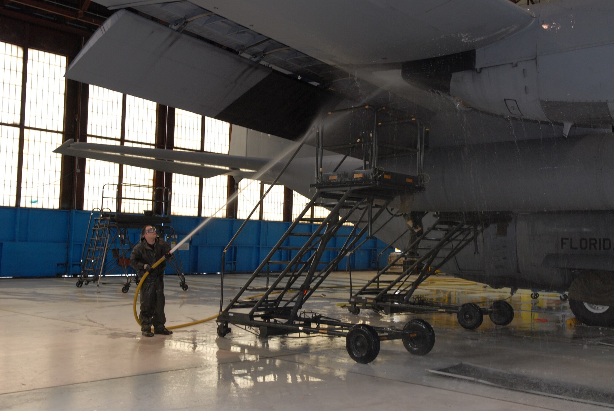 Tech. Sgt. Adam Mace of the 130th Aircraft Maintenance Squadron at Yeager Airport, W.Va. sprays down the underside of a wing on a WC-130H Hercules plane, Friday, Jan. 8, 2010. It took nine hours for a crew of four airmen to soap up, scrub down and spray off the aircraft. Maintenance personnel wash each aircraft twice a year. (U.S. Air Force photo by Staff Sgt. William Hinamon/Released)