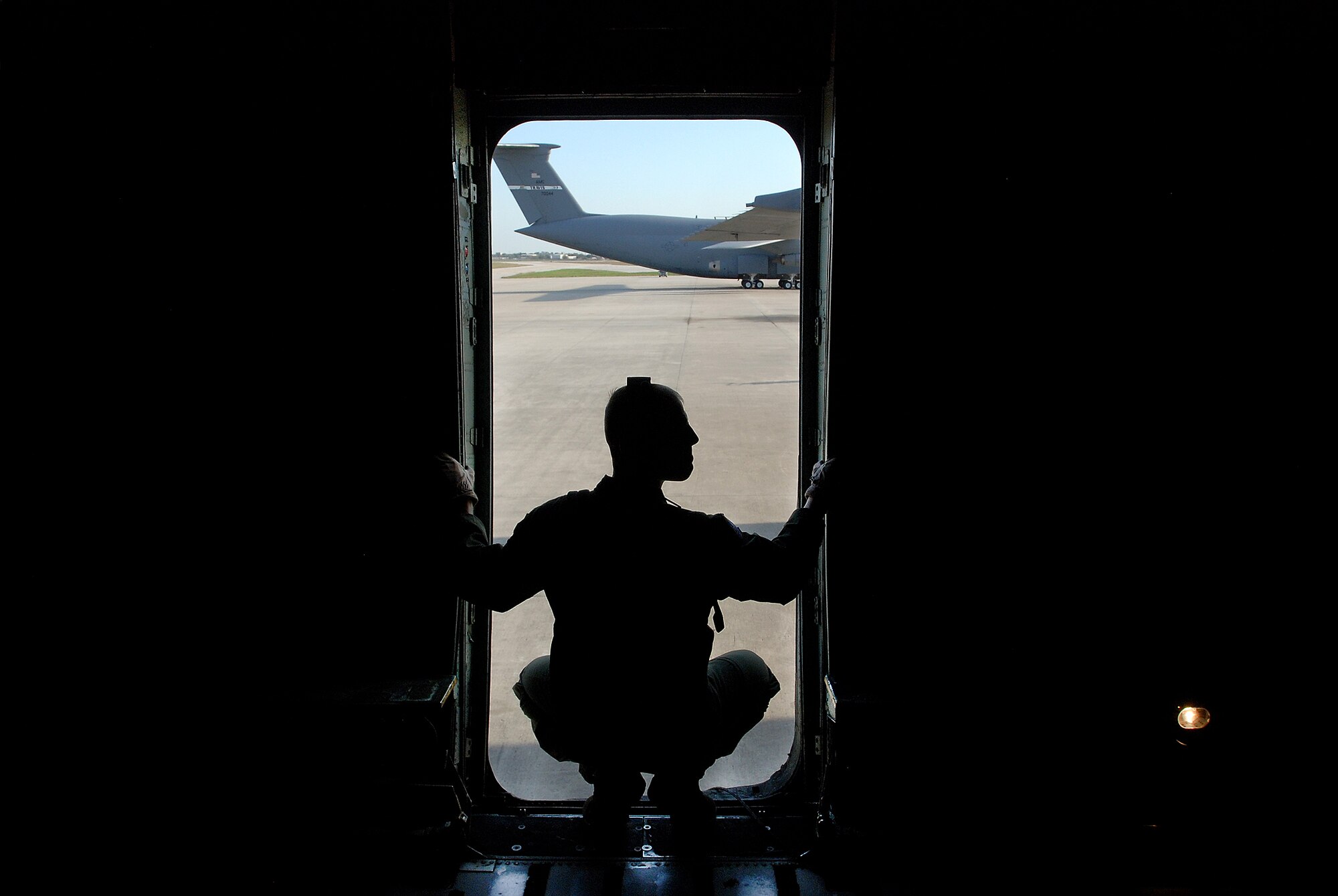 Staff Sgt. Marcus Wasden, 68th Airlift Squadron loadmaster, watches from the door of a C-5A Galaxy as a stair truck is being driven to the aircraft allow the passengers to deplane. The passengers are member of the 2009 Boss' Day tour group at the 433rd Airlift Wing, Lackland Air Force Base, Texas. (U.S. Air Force photo/Airman 1st Class Brian McGloin)
