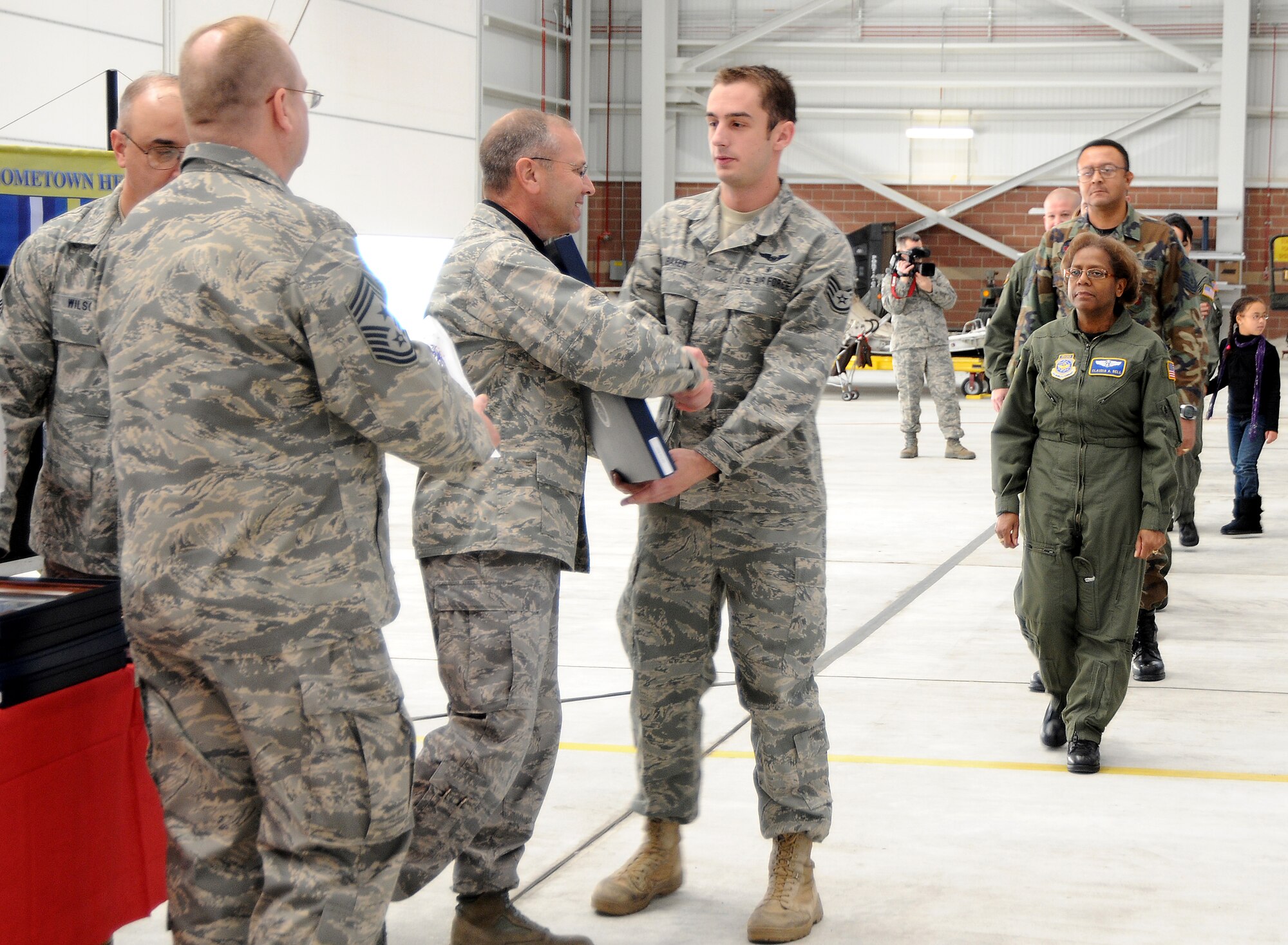 Staff Sgt. Troy Baker is presented with a framed letter and coin by Col. Roger Nye, 167th Airlift Wing commander, during the first Hometown Hero Salute recognition program on Sunday, December 6, 2009. In August 2008, Gen. Craig R. McKinley, chief of the National Guard Bureau, sanctioned the ANG Hometown Heroes Salute recognition program. The purpose of this program is to celebrate and honor Airmen, families, communities and those special supporters who have significantly contributed to supporting our Airmen and ANG?s mission. (U.S. Air Force photo by Msgt Emily Beightol-Deyerle)
