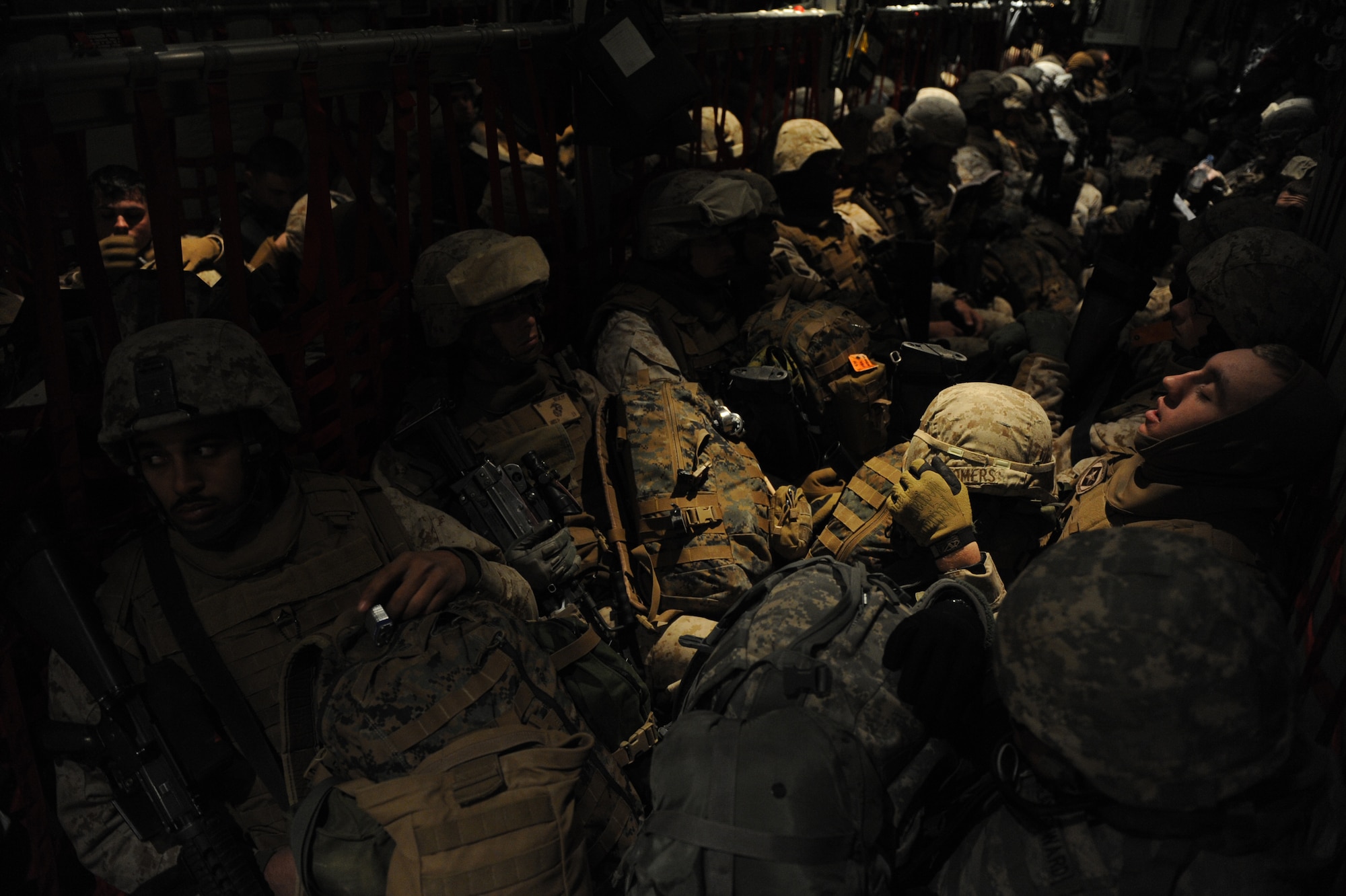 Marines wait for take-off of a C-130J Super Hercules to transport them to their next location, Jan. 7. at  Kandahar Airfield, Afghanistan. The Marines are assigned to 30th Battalion, 6th Marines, Headquarters Company and the C-130J is out of Little Rock Air Force Base, Ark,. A routine channel mission is a twelve-hour shift to deliver passengers and cargo to various locations throughout Afghanistan. (U.S. Air Force/Staff Sgt. Manuel J. Martinez)