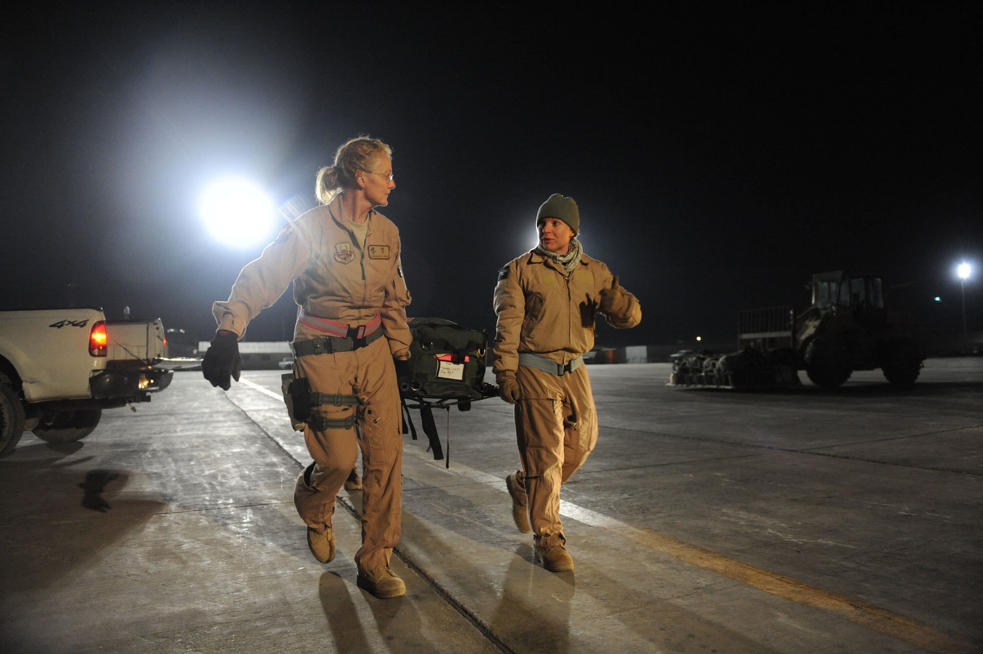 Maj. Debbie Lehking, (left) a 451st Expediitionary Aeromedical  Evacuation Flight nurse and a co-worker load their equipment on a C-130J Super Hercules Jan. 6 at  Bagram Air Base, Afghanistan. (U.S. Air Force/Staff Sgt. Manuel J. Martinez)