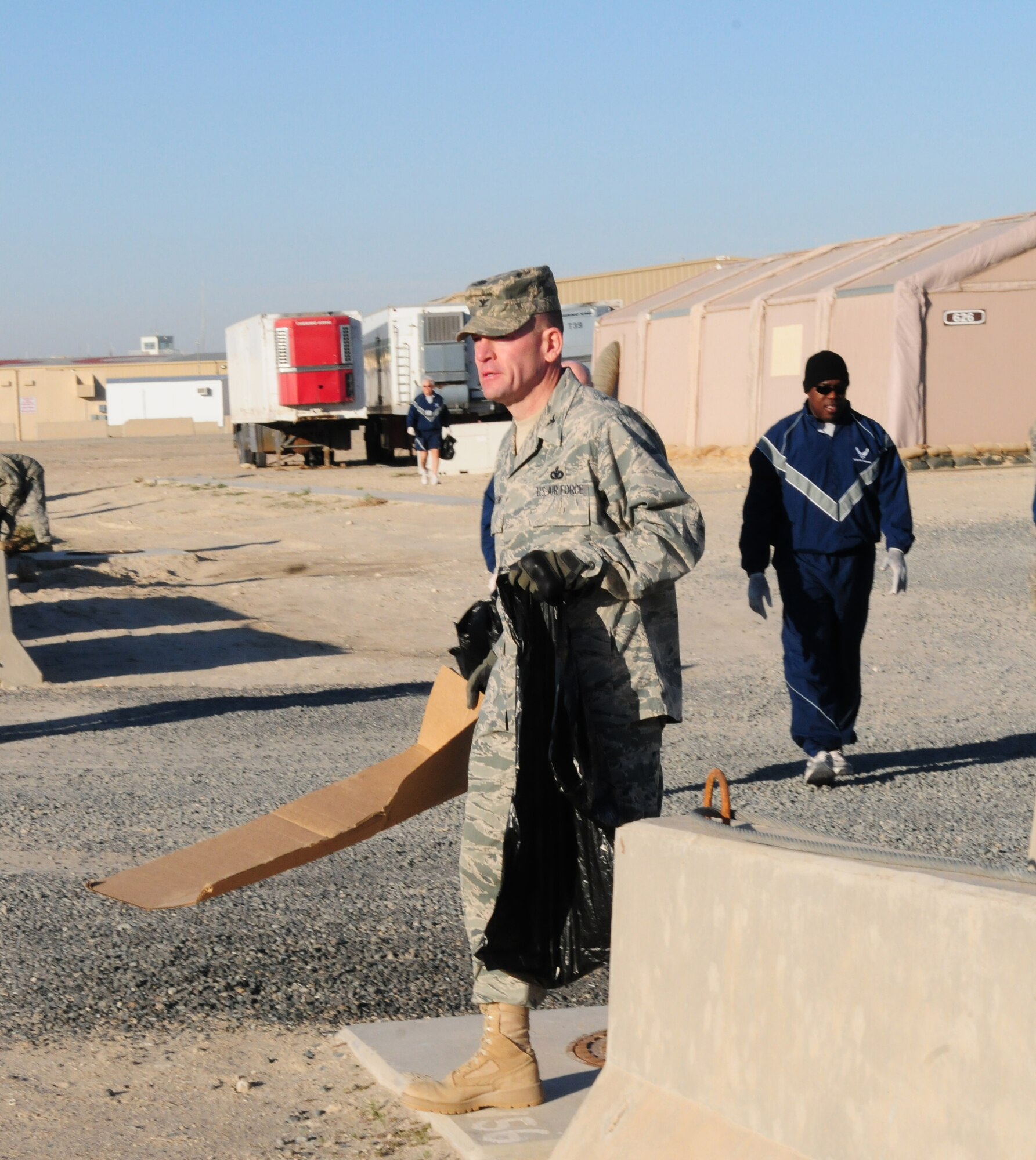 SOUTHWEST ASIA -- U.S. Air Force Col. Richard McComb, 386th Expeditionary Mission Support Group commander, collects a piece of cardboard Jan. 9, 2010 during the weekly base cleanup at an air base in Southwest Asia. The event is a volunteer opportunity held every Saturday morning at the base, also known as "The Rock". (U.S. Air Force photo by Staff Sgt. Lakisha A. Croley/Released) 