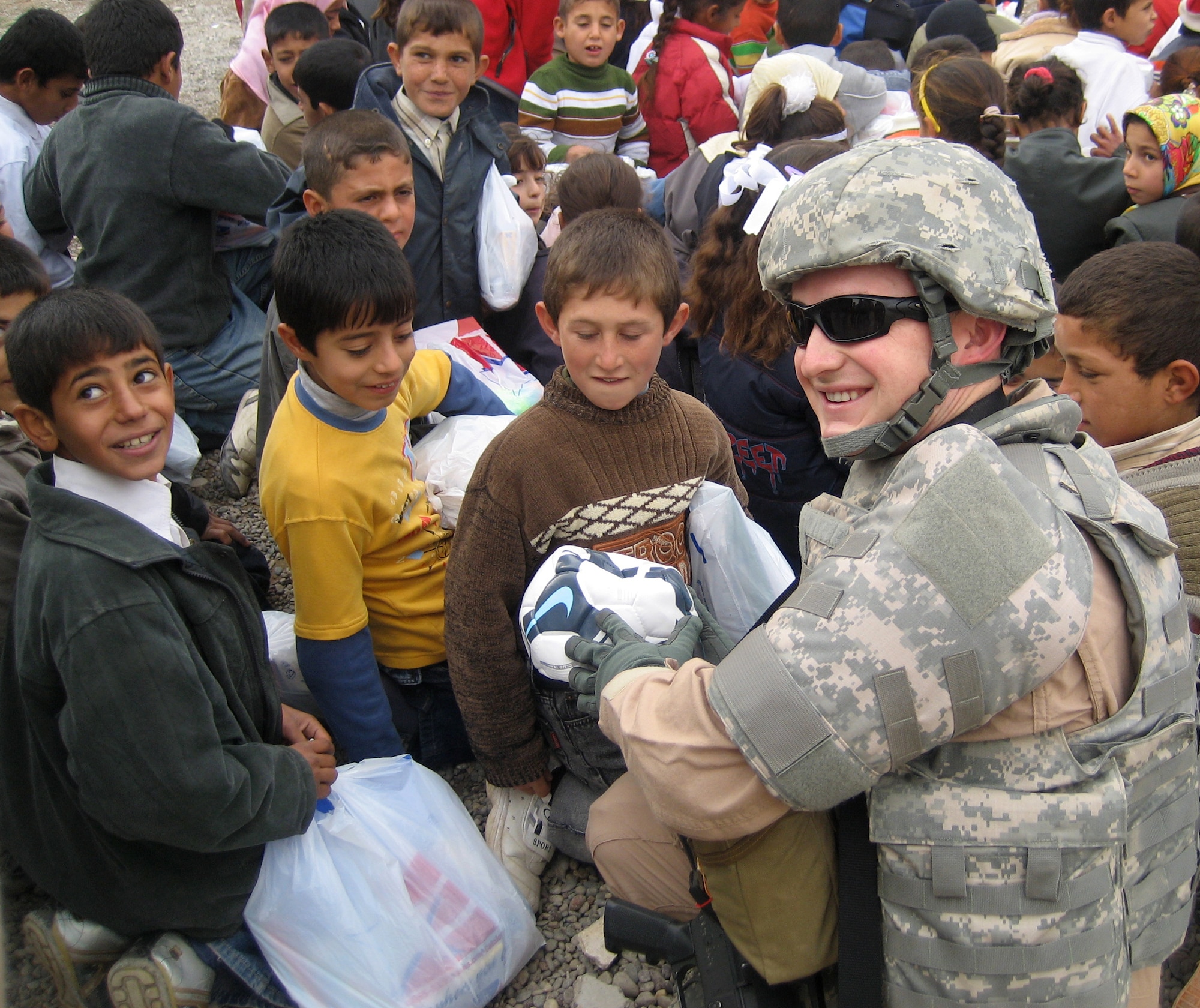 KIRKUK REGIONAL AIR BASE, Iraq – Vice President of the Rising Four Club, Senior Airman Robert Evans, 506th Expeditionary Operation Support Squadron Airfield Management, hands out soccer balls and school supplies at Al-Harmezah Elementary School during Operation Soccer Ball Jan. 5, 2010. Operation Soccer Ball was a humanitarian effort sponsored by the Kirkuk Regional Air Base's Rising Four Club. He is a native of Orlando, Fla.,  and is deployed from the 21st Operation Support Squadron, Peterson Air Force Base, Colo.   (U.S. Air Force photo/courtesy photo)