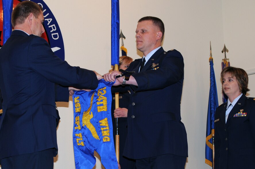 124th Mission Support Group Commander Col. Christopher D. Rood (left) retires the mission support flight flag with Lt. Col. Michael R. Knowles as Maj. Donene E. Rognlie looks on. The inactivation of the services flight ceremony was held Jan. 9 at Gowen Field in conjunction with the redesignation of the mission support flight into the new 124th Force Support Squadron, which combines services, personnel and family support. (Air Force photo by Staff Sgt. Heather Walsh)(Released)