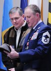Chief Master Sgt. Lyle Spangler presents Col. (retired) Kenny Ray with a memento of being named an honorary chief master sergeant at Duke Field, Jan. 9.  Colonel Ray was a former 711th Special Operations Squadron commander and 919th Special Operations Wing vice commander.  The impromptu presentation took place during Chief Spangler’s retirement ceremony.  Chief Spangler began his 36-year career in 1973 and transitioned to the reserves in 1978.  The chief completed his career as a member of the 711th SOS.  U.S. Air Force photo by Tech. Sgt. Samuel King Jr.