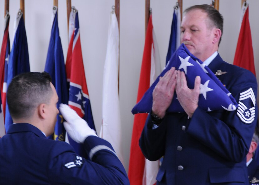 Chief Master Sgt. Lyle Spangler accepts the American flag from an Airman from Eglin Air Force Base honor guard during his retirement ceremony at Duke Field, Jan. 9.  Chief Spangler began his 36-year career in 1973 and transitioned to the reserves in 1978.  The chief completed his career as a member of the 711th Special Operations Squadron.  U.S. Air Force photo by Tech. Sgt. Samuel King Jr.