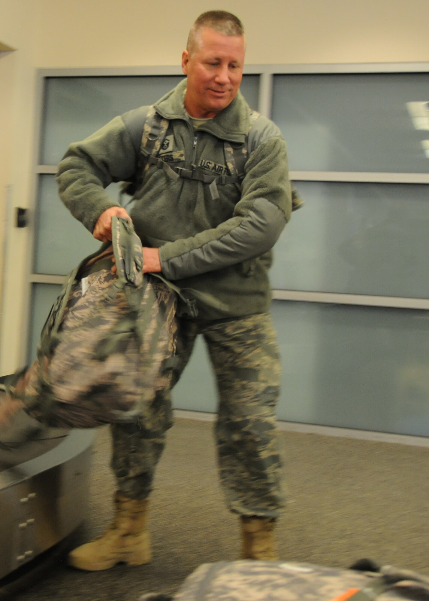 Master Sgt. Donald Peters, 919 Medical Squadron first sergeant, pulls his last bag off the belt before heading home after a deployment to Balad, Iraq, Jan. 9.  Wife, Yvonne Peters and members of the 919 MDS met him at the airport to welcome him back.  U.S. Air Force photo by Tech. Sgt. Samuel King Jr.