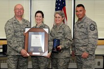 174th Fighter Wing Support Group Commander Col. Harvey M. Van Wie Jr., Lt. Col. Barbara J. Hisel and Senior Master Sgt. Gregory W. Giamas present Master Sgt. Jessica J. Macmaster with the "Hometown Heroes" plaque. The plaque is given out to members of the Air National Guard who have deployed since the attacks on September 11th in support of Operations Enduring Freedom and Iraqi Freedom. (RELEASED)