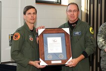 174th Fighter Wing Operations Group Commander Col. Greg A. Semmel presents Lt. Col. Kurt R. Larson with the "Hometown Heroes" plaque. The plaque is given out to members of the Air National Guard who have deployed since the attacks on September 11th in support of Operations Enduring Freedom and Iraqi Freedom. (RELEASED)