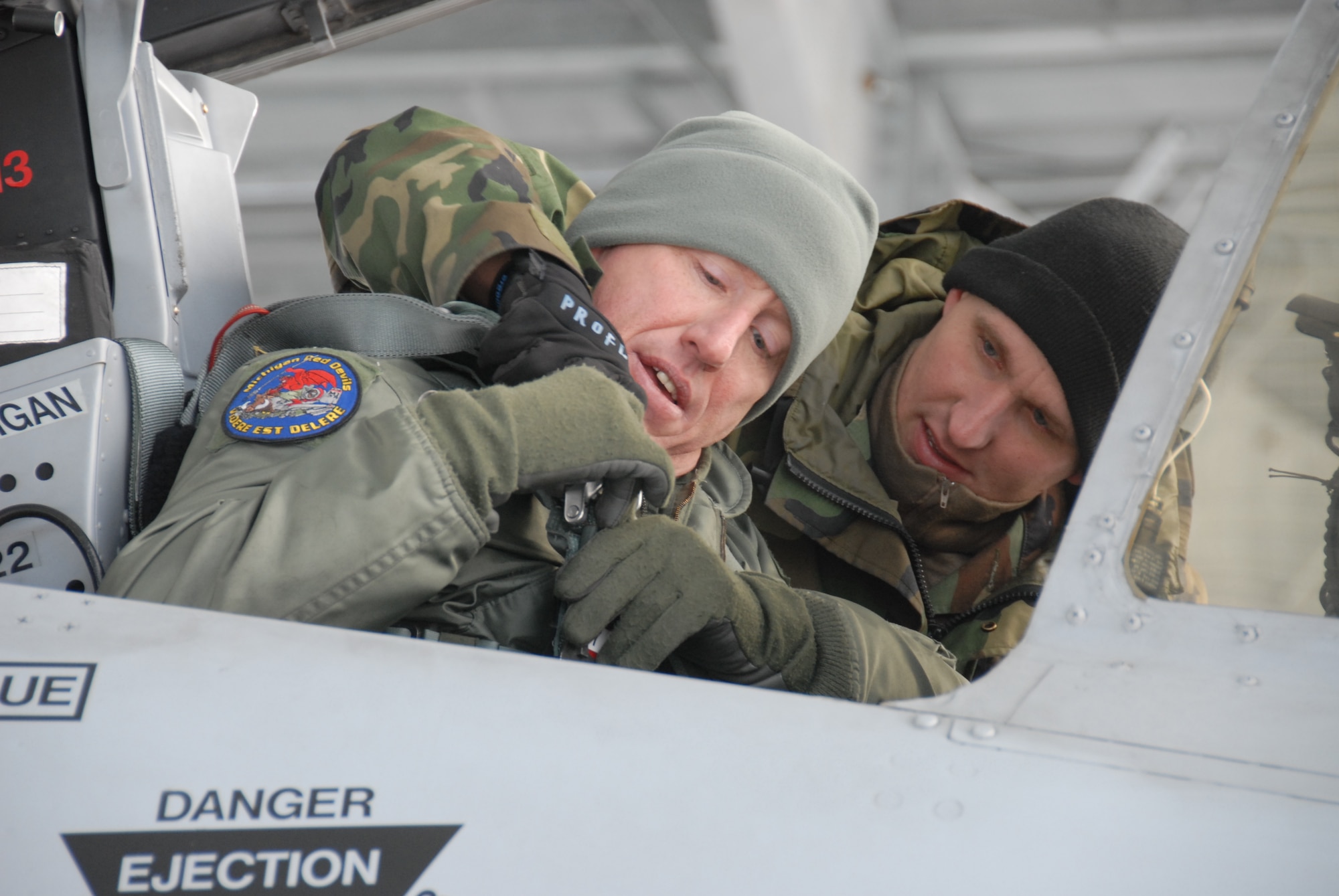 Lt. Col. Doug Champagne, 107th Fighter Squadron commander, gets strapped into the A-10 that he will deploy in as part of "Operation Demons to DM" on Saturday, January 9.  After just six months of flying the A-10 mission from Selfridge Air National Guard Base, the 107th's "Red Devils" along with approximately 120 maintenance and support personnel, deployed to Davis-Monthan AFB, Ariz. There, the Michigan Guardsmen will take advantage of the ideal weather conditions to increase training tempos to prepare to upcoming missions in support of global operations. (photo by MSgt Clancey Pence, 127th Public Affairs)