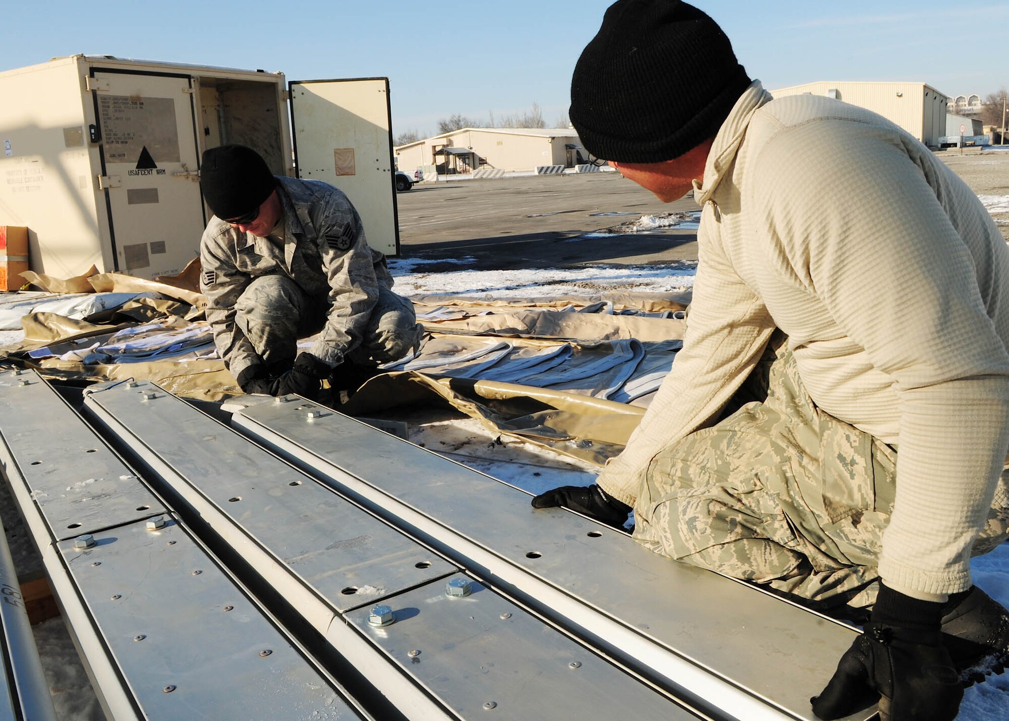 TRANSIT CENTER AT MANAS, Kyrgyzstan - Airmen from the U.S. Air Forces Central Forward Construction Office A-7 piece together parts for a new 4K Dome tent here Jan. 11. The new tents are being built to support the influx of Airmen, Soldiers, Sailors and Marines who pass through the TC en route to Afghanistan. The team, deployed from the 49th Material Maintenance Squadron, Holloman Air Force Base, N.M., travels to USAFCENT bases in the area of responsibility to construct temporary structures. (U.S. Air Force photo by Senior Airman Nichelle Anderson)