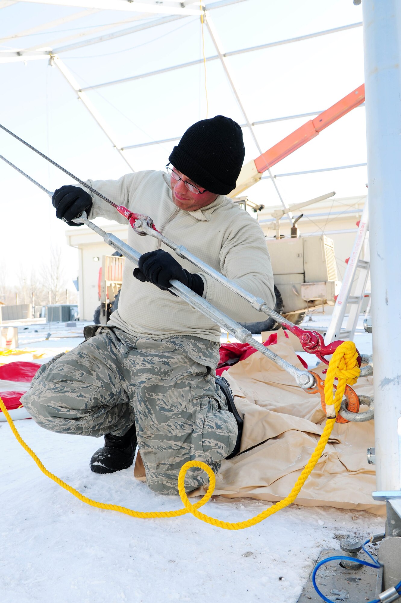 TRANSIT CENTER AT MANAS, Kyrgyzstan - Senior Airman James Hastings, U.S. Air Forces Central Forward Construction Office A-7, tightens the cables to hold a beam on a new 4K Dome tent here Jan. 11. The new tents are being built to support the influx of Airmen, Soldiers, Sailors and Marines who pass through the TC en route to Afghanistan. Airman Hastings is deployed from the 49th Material Maintenance Squadron, Holloman Air Force Base, N.M. (U.S. Air Force photo by Senior Airman Nichelle Anderson)