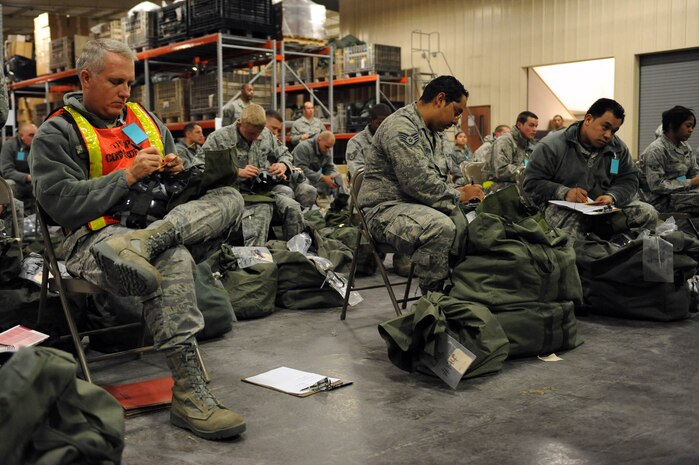 NELLIS AIR FORCE BASE, Nev. -- Col. Kevin Fox, 99th Mission Support Group commander, and various Airmen from the 99th Air Base Wing simulate deploying  at the deployment center during an operational readiness exercise Dec. 21. The 99th ABW is preparing for an operation readiness inspection Jan 25-29. (U.S. Air Force photo by Airman 1st Class Bret Clashman)