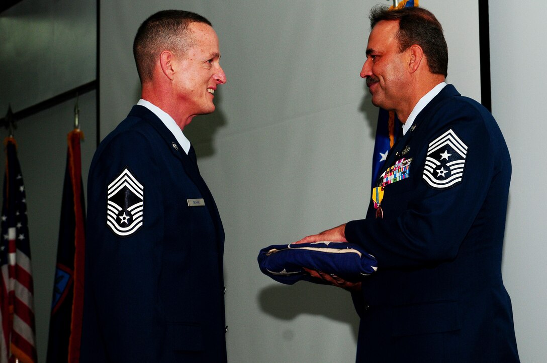 ANDERSEN AIR FORCE BASE Guam - Chief Master Sgt. David Graak, 734th Air Mobility Command, presents 36th Wing Command Chief Master Sergeant Saniford D. "Bud" Andree, Jr., his retirement flag at the Sunrise Conference Center Jan. 8. Before retiring, Chief Andree hands over the reins of command chief of the 36th Wing to Chief Master Sgt. Allen Mullinex. (U.S. Air Force photo by Airman 1st Class Jeffrey Schultze)