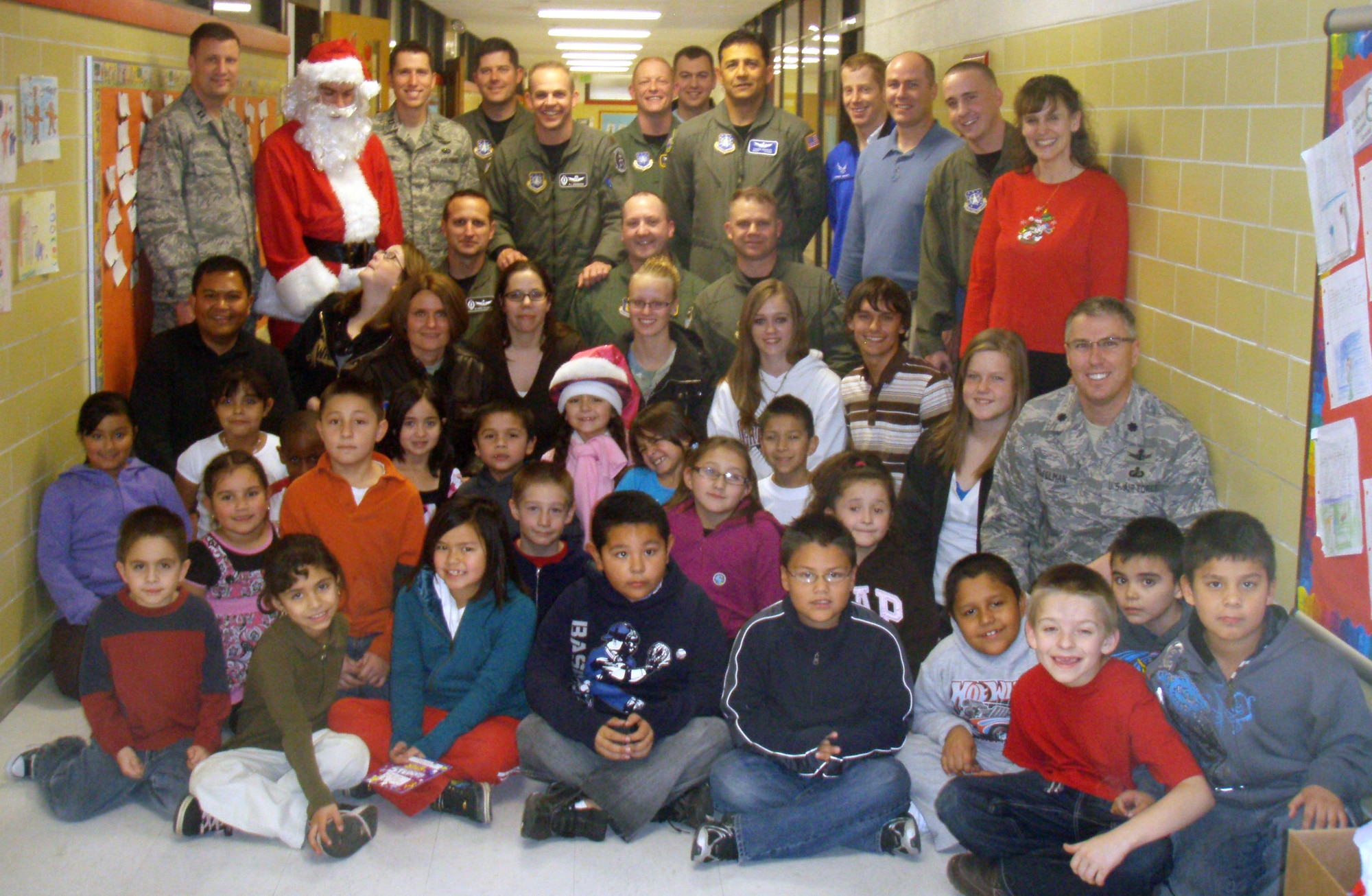 BOULDER, Colo. -- Posing with Santa Claus and second-graders from Alsup Elementary in Commerce City, Colo., Dec. 17, 2009, are volunteers from 460th Operations Group Detachment 1. These volunteers joined with Space-Based Infrared System Combined Task Force members, the student council at Marino High School and others to share gifts and cookies with the second-grade class. (U.S. Air Force photo)