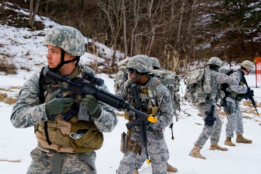 MISAWA AIR BASE, Japan -- Members of the 35th Civil Engineer Squadron Explosive Ordinance Disposal flight check for threats during a tactical reload drill Jan. 8 at Ski Hill. The drill was part of a bi-monthly, four-mile ruck march. (U.S. Air Force photo/Senior Airman Jamal D. Sutter)