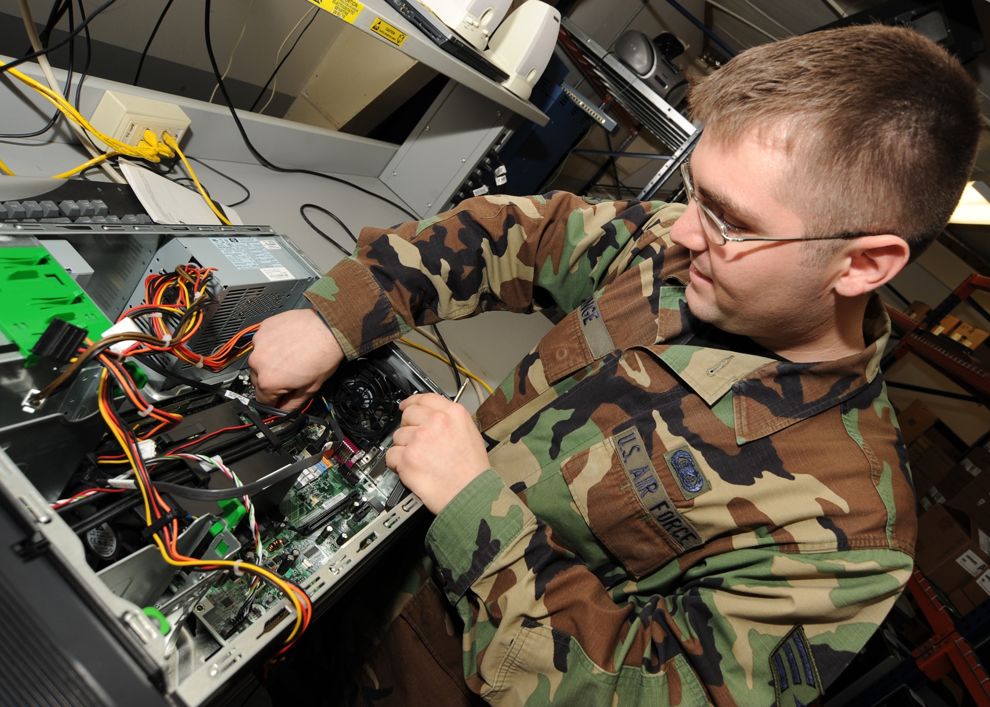 Senior Airman Trevor Winge, 22nd Communications Squadron, transfers a power supply, Dec. 28, 2009, from one computer to another with a better-formatted motherboard, a computer’s main circuit board, at McConnell Air Force Base, Kan. Airman Winge works in the personal computer maintenance section of the 22nd CS Communications Focal Point. Airmen in his section are responsible for fixing and upgrading work-related computers for Team McConnell members. (U.S. Air Force Photo/Senior Airman Ruiz)