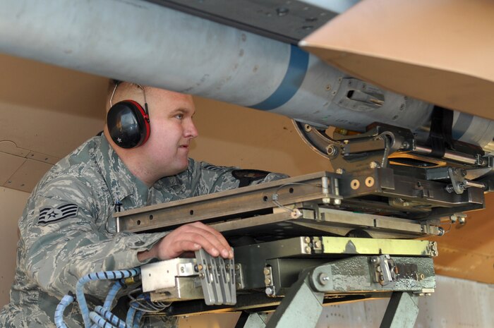 NELLIS AIR FORCE BASE, Nev.-- Staff Sgt. Anthony Fallon, a weapons loader. 57th Aircraft Maintenance Squadron, adjusts the controls of the MJ-1 bomb lift truck while loading a AIM-120 missile onto an F-15 Eagle during the load team competition here Jan. 8.  The quarterly weapons load crew competition tests the skills of airman on six different teams. The Airmen are judged on speed, accuracy and safety. (U.S Air Force photo by Staff Sgt. Taylor Worley)(Released)
