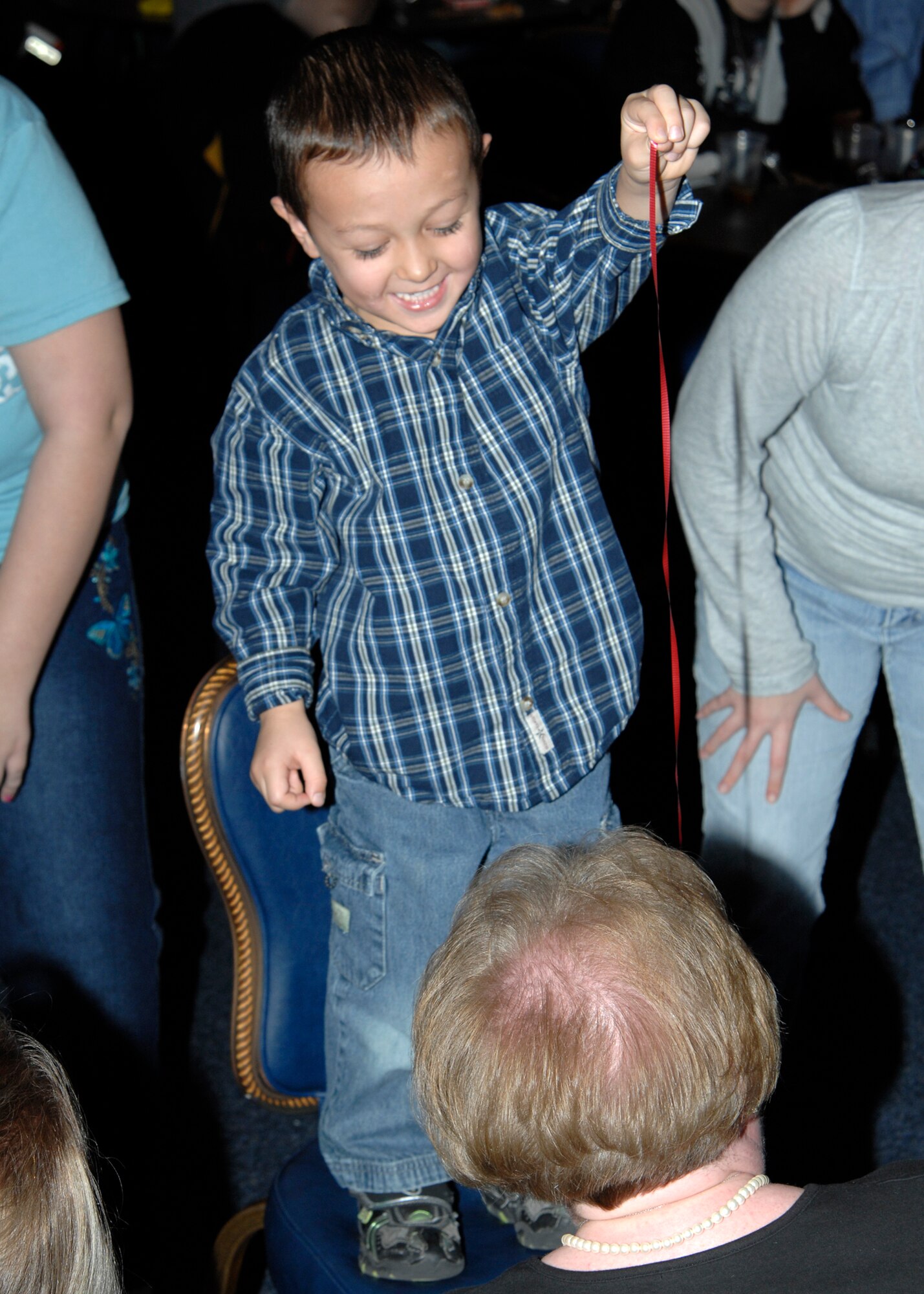 Isaac Vorderlandwehr, 4, a Team McConnell family member, feeds a donut to Pam Porsch, 22nd Comptroller Squadron, during the New Year’s Eve party, Dec. 31, 2009, McConnell Air Force Base, Kan. Children fed adults donuts tied streamers in a donut bobbing competition to see which child-adult team could eat the entire donut first. (U.S. Air Force/Airman 1st Class Justin Shelton)