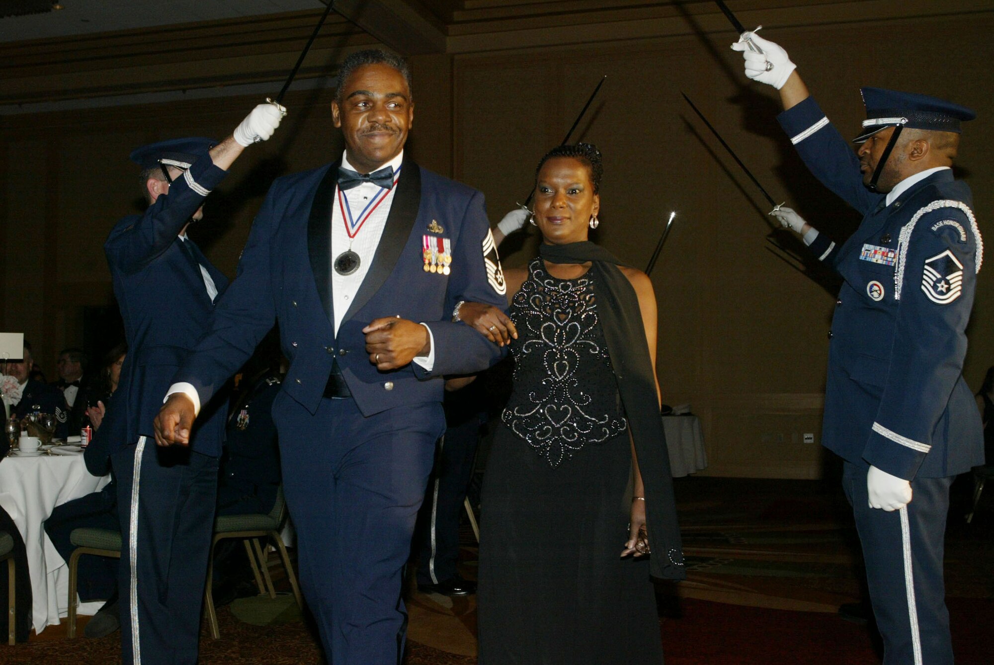 Chief Master Sgt. Tyrone Anderson, accompanied by his wife Angi, enters the ballroom under raised sabers provided by the 94th Airlift Wing Honor Guard Saber Team, marking the beginning of the 2010 Chiefs Recognition Ceremony held Jan. 9 at the Renaissance Waverly. Chief Chief Anderson is the Functional Manager, Aviation Resource Management with the 22nd Air Force. (U.S. Air Force photo/Don Peek)