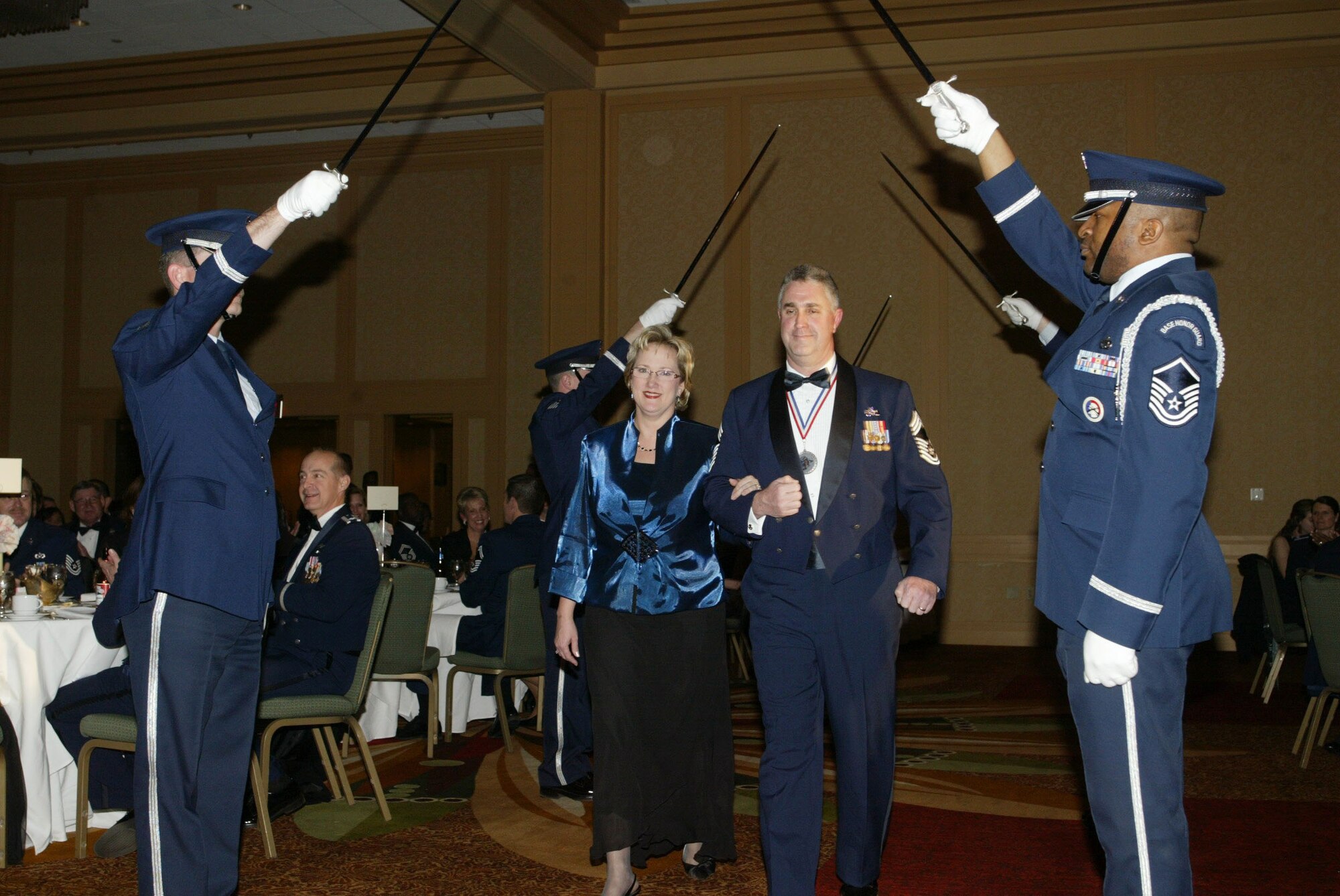 Chief Master Sgt. Ward Durant accompanied by his wife Allison enters the ballroom under raised sabers provided by the 94th Airlift Wing Honor Guard Saber Team, marking the beginning of the 2010 Chiefs Recognition Ceremony held Jan. 9 at the Renaissance Waverly. Chief Durant is the Civil Engineering Manager with the 628th Civil Engineer Flight.