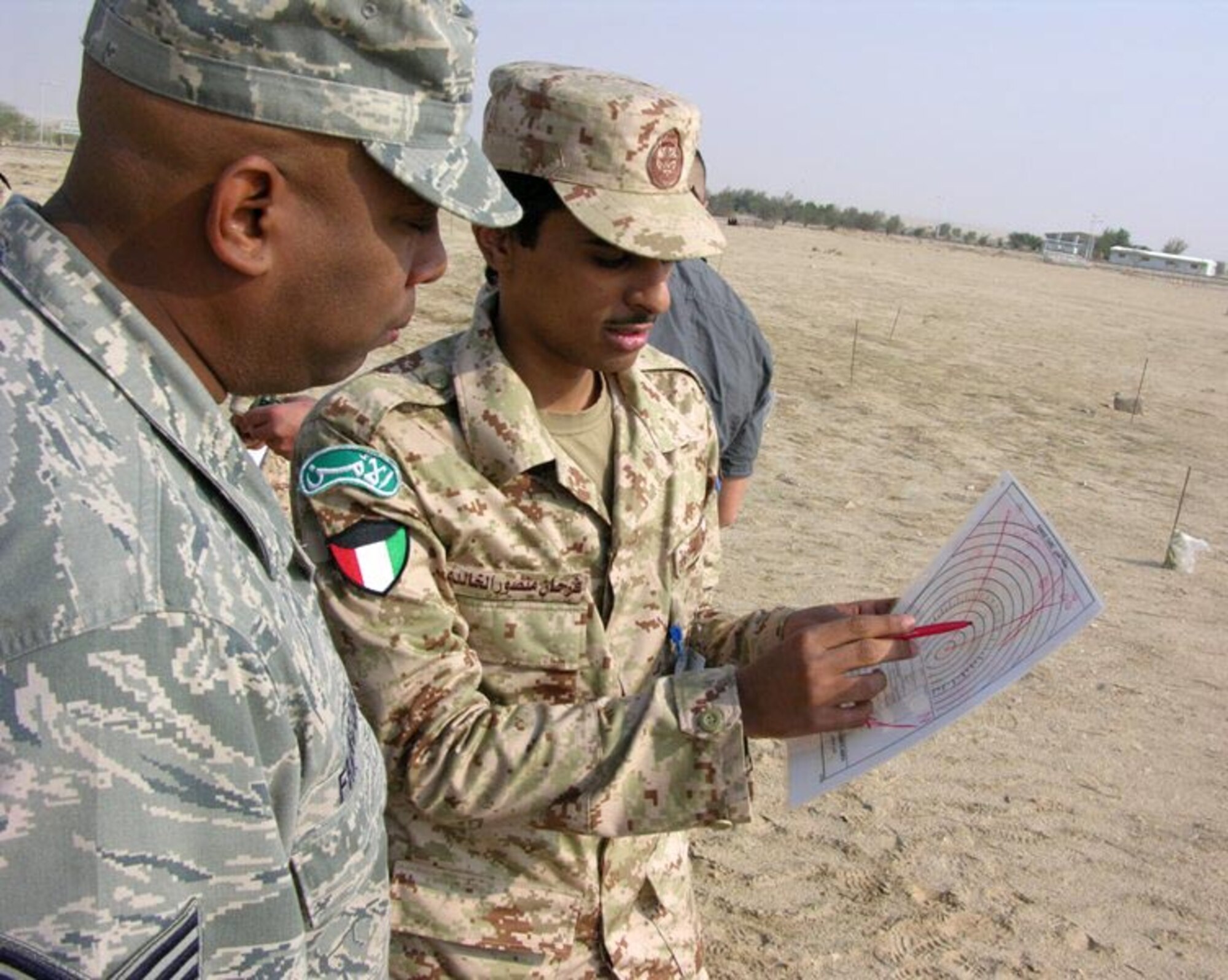 SOUTHWEST ASIA -- Staff Sgt. Ernest Francois, a 387th Expeditionary Security Forces Squadron member deployed from Holloman Air Force Base, N.M., speaks with a member of the Kuwaiti military during host nation training here recently. The presentations and instructions delivered during the training were given by U.S. Air Force Security Forces and then translated through linguist, all of whom are assigned to the 386th ESFS. (Courtesy photo)