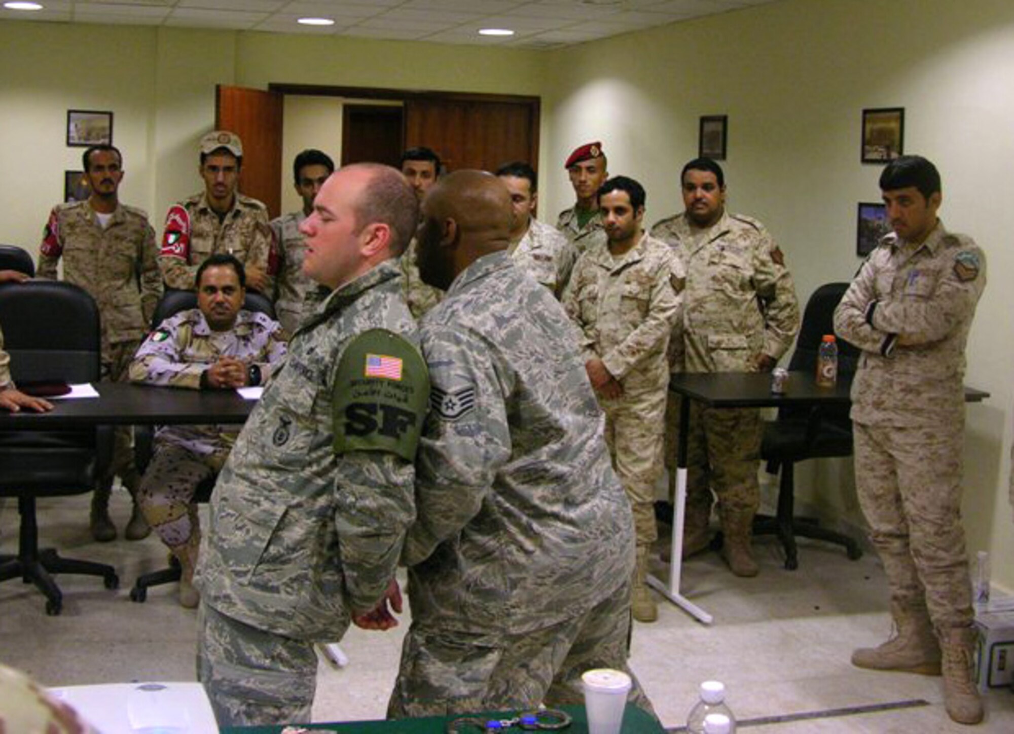 SOUTHWEST ASIA -- Staff Sgt. Ernest Francois, a 387th Expeditionary Security Forces Squadron member deployed from Holloman Air Force Base, N.M., gives a classroom demonstration on handcuffing to members of the Kuwaiti military during host nation training here recently. The training was designed to strengthen the ground combat capability of the host nation military forces. (Courtesy photo)
