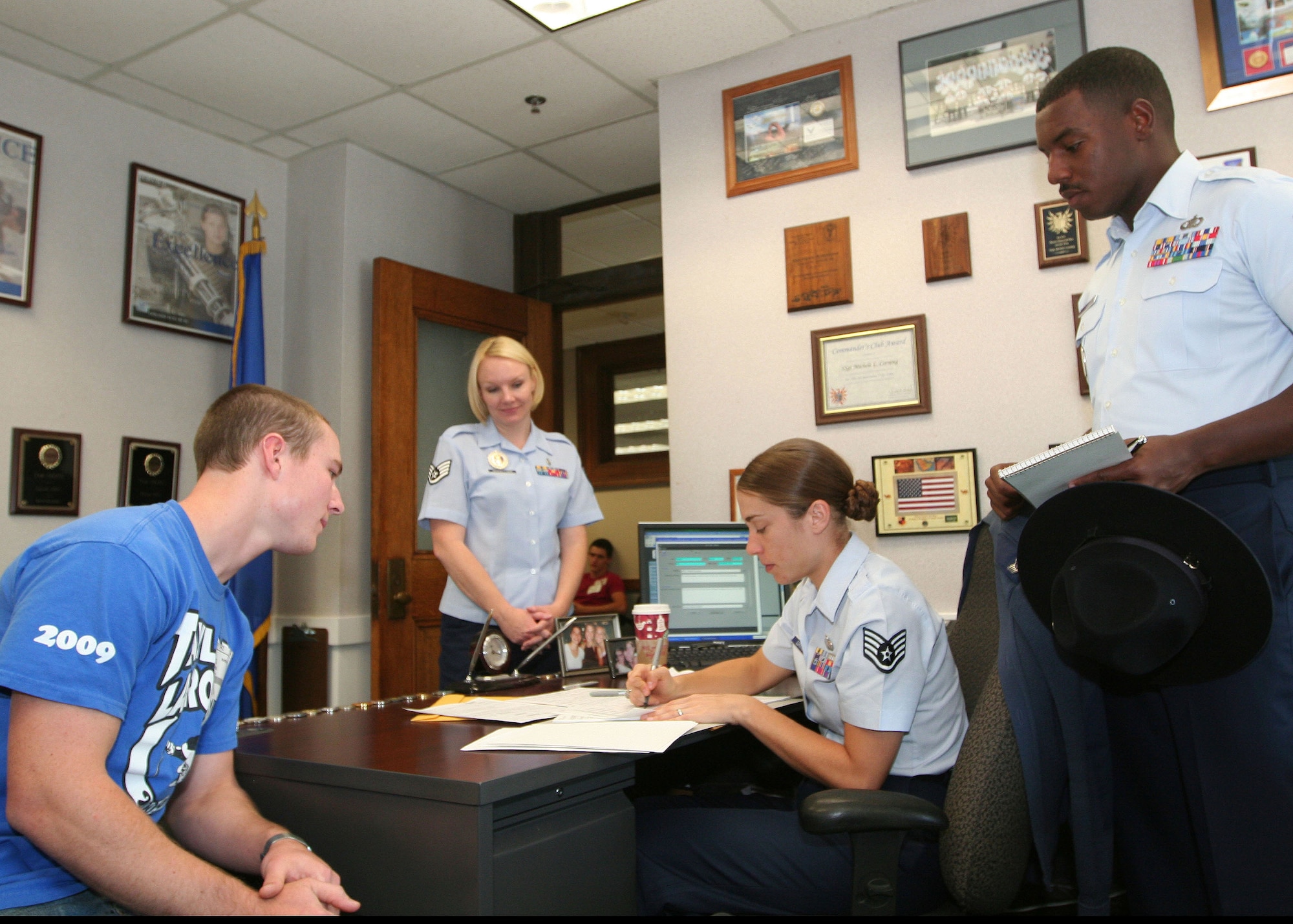 323rd Training Squadron military training instructor Staff Sgt. Bobby Bass and 341st Recruiting Squadron recruiter Staff Sgt. Cheryl Vercellona observe 341st Recruiting Squadron military entrance processing station liaison Staff Sgt. Michele Corning assisting an applicant with his entry paperwork at the Houston MEPS. Recruiters from the 341st Recruiting Squadron and military training instructors from the 323rd Training Squadron took turns shadowing each other to gain insight into each other's jobs. (U.S. Air Force photo/Master Sgt. Thomas Deering)
