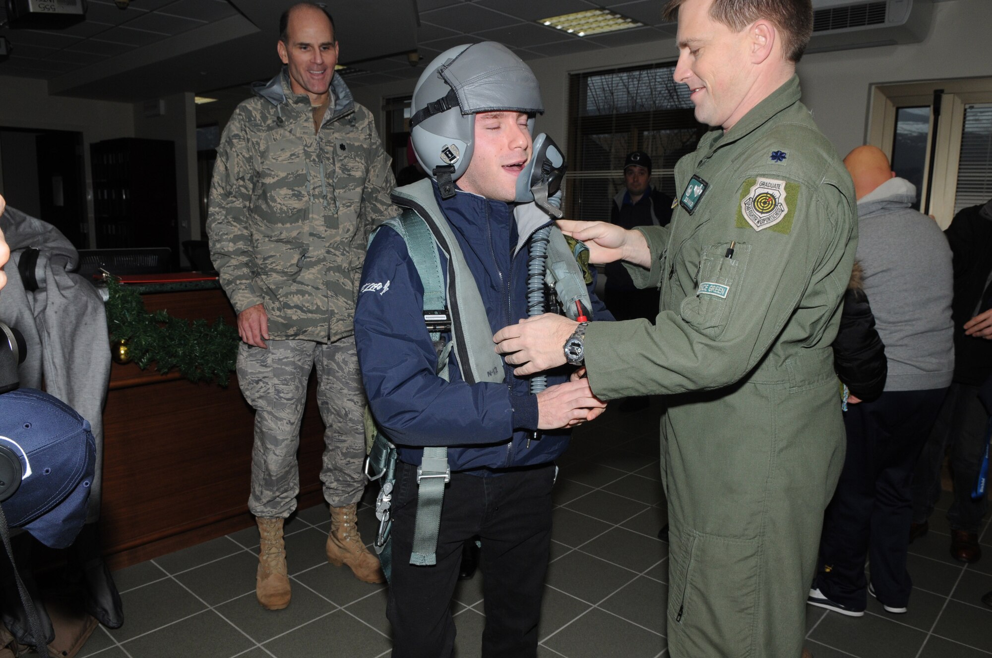 Lt. Col. Robert P. Winkler, 555 Fighter Squadron commander, shows off flight equipment to members of the Gymnasium Special Swim team during a visit here Jan. 9. The team, which trains twice a week at the Aviano swimming pool, consists of swimmers with intellectual disabilities. They are part of the Special Olympics program, which is the world's biggest sports organization for people with disabilities. (U.S. Air Force photo/Staff Sgt. Mercedes Crossland)