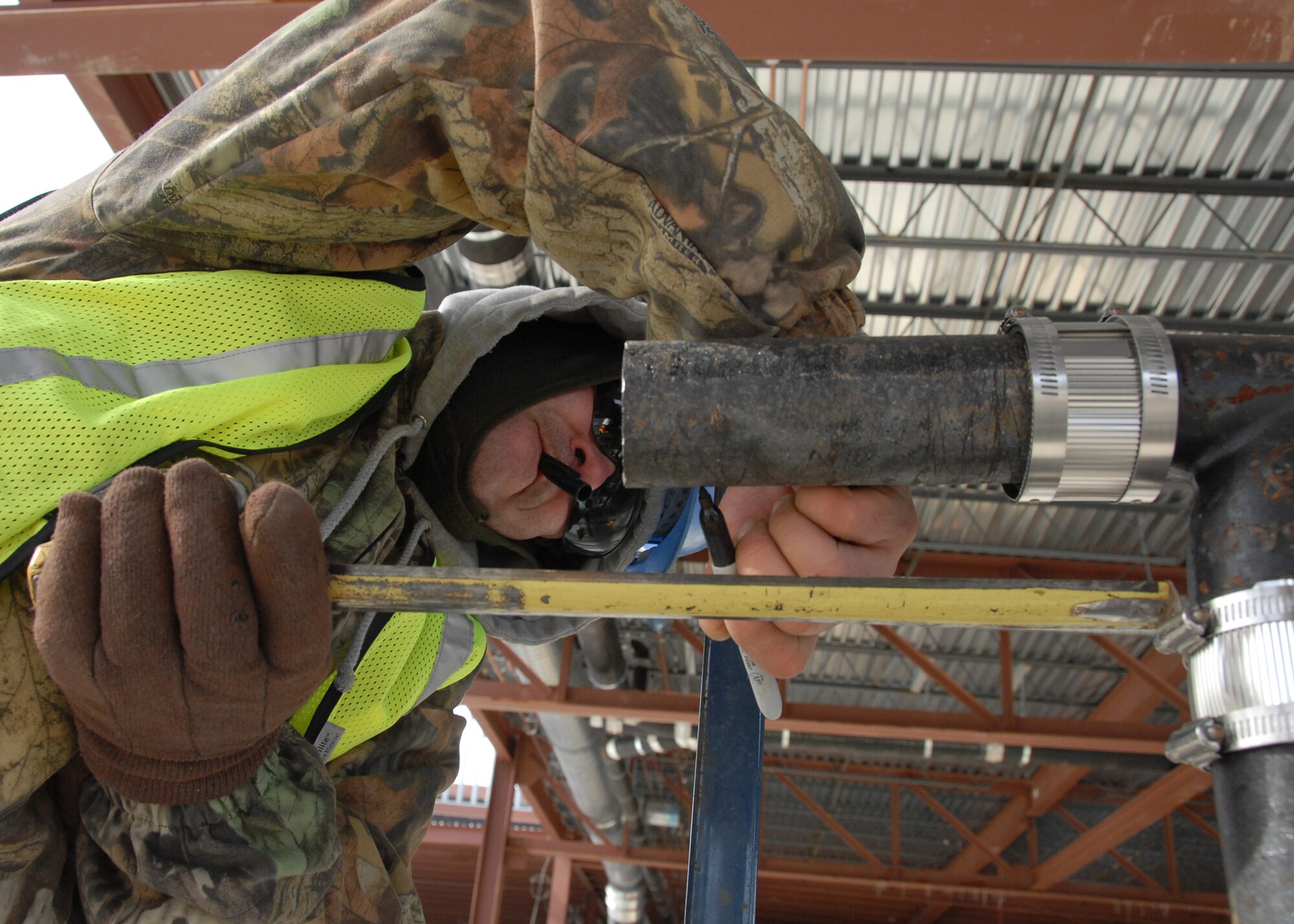 John Luciano marks a pipe with a marker Jan. 8 at the Joint Strike Fighter Training Facility construction site.  The temperatures and wind chill halted some of the construction activities Jan. 8, but work still continued.  Drills, saws, raised lifts and heavy movers could be heard all around the site.  (U.S. Air Force photo/Samuel King Jr.)