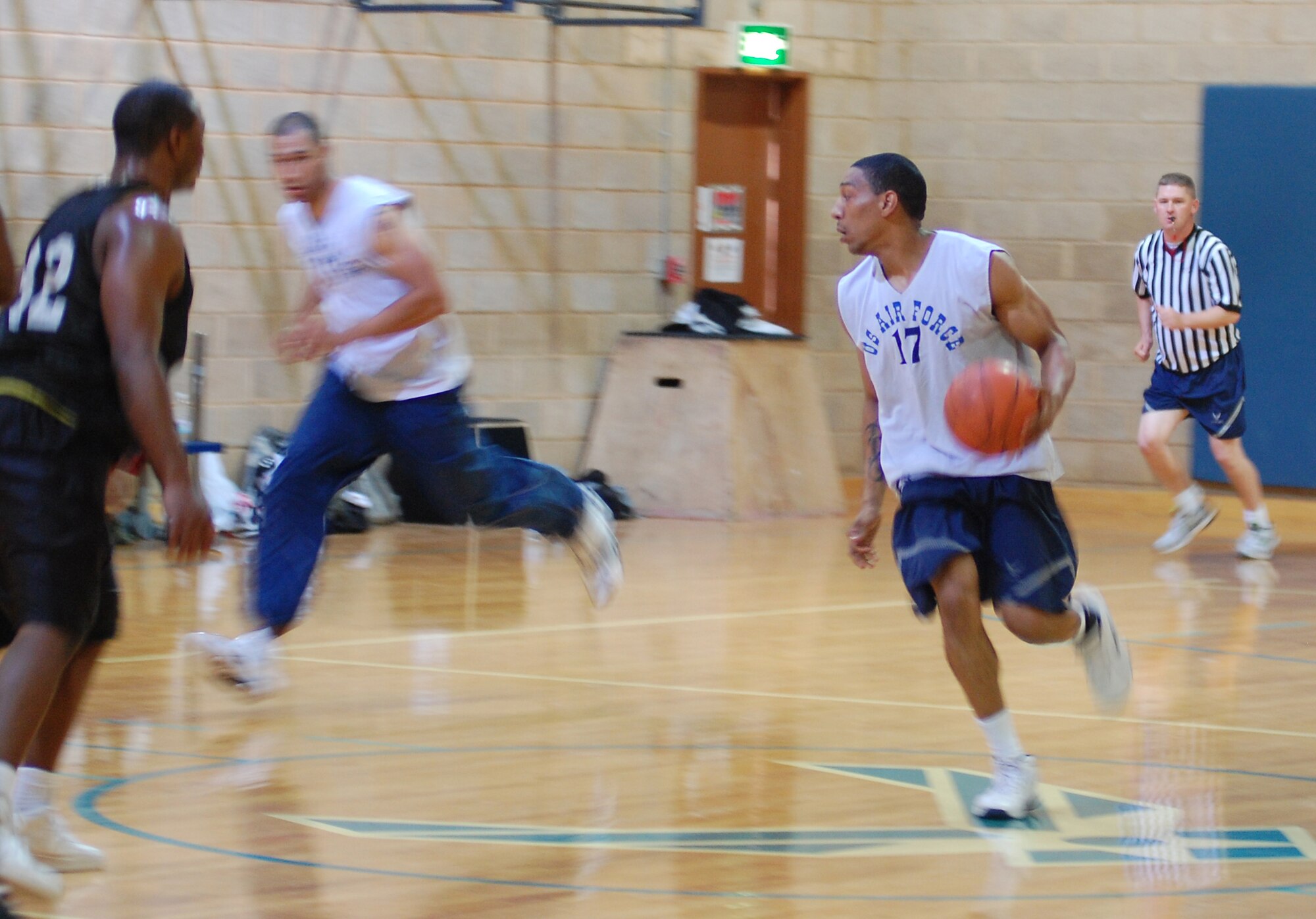 U.S. Air Force Senior Airman Raymond Valencia brings the ball across half court with Senior Airman Jon-Moses Robinson trailing close by during a game against U.S. Army soliders Jan. 10, 2010 at an air base in Southwest Asia. The Air Force beat the Army 44-37. The Soliders are stationed at a logistics support area nearby the air base. (U.S. Air Force photo by Staff Sgt. Lindsey Maurice/Released)