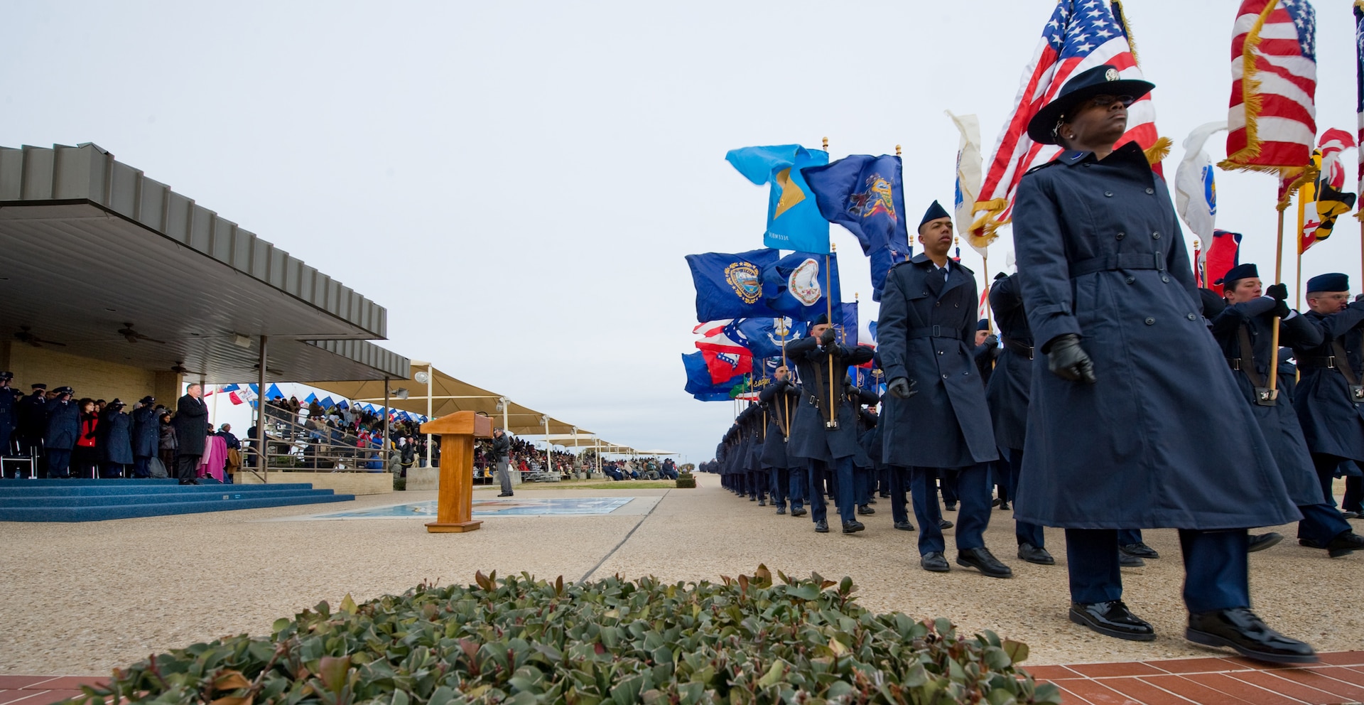 Secretary of the Air Force Michael Donley (top of steps), stands with his hand over his heart as national and state flags are paraded past in review during a Basic Military Training graduation ceremony Jan. 8, 2010, at Lackland Air Force Base, Texas. (U.S. Air Force photo/Lance Cheung)