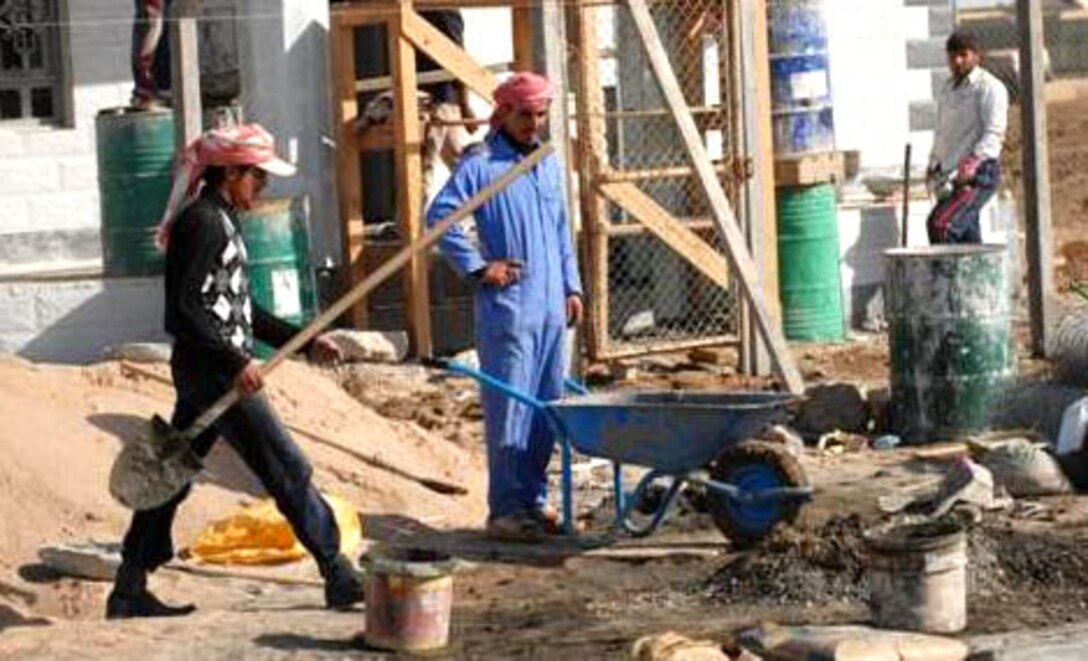 Iraqi workers finish the last steps of construction of the Al Warka