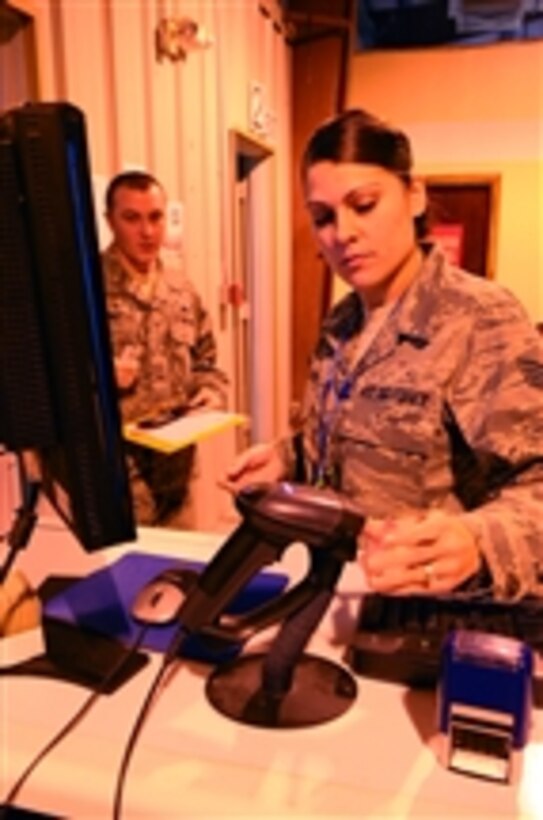 U.S. Air Force Staff Sgt. Jessica Calloway, the assistant non-commissioned officer in charge of the nightshift reception center with the 379th Expeditionary Force Support Squadron, scans an airman’s identification card in southwest Asia on Jan. 4, 2010.  Calloway is deployed from Stuttgart, Germany.  