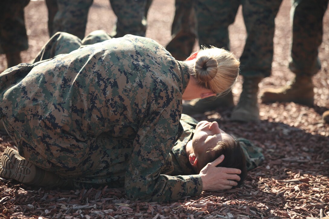 Petty Officer 1st Class Sarah Reed, a Combat Lifesaver Course instructor, checks for breathing on a simulated casualty during the CLS course hosted by the Advisor Training cell at Camp Pendleton, Nov. 16.  The CLS course equips Marines with fundaments to treat combat casualties.