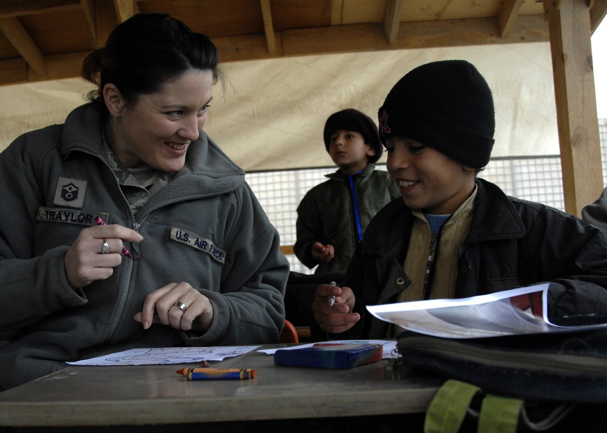 Master Sgt. Wenesday Traylor and an Afghan student color together during a volunteer opportunity at the Kandahar Airfield Bazaar School, Jan. 2, 2010. Sergeant Traylor is the first sergeant for the 73rd Expeditionary Air Control Squadron from Mountain Home Air Force Base, Idaho. (U.S. Air Force photo/Senior Airman Timothy Taylor)