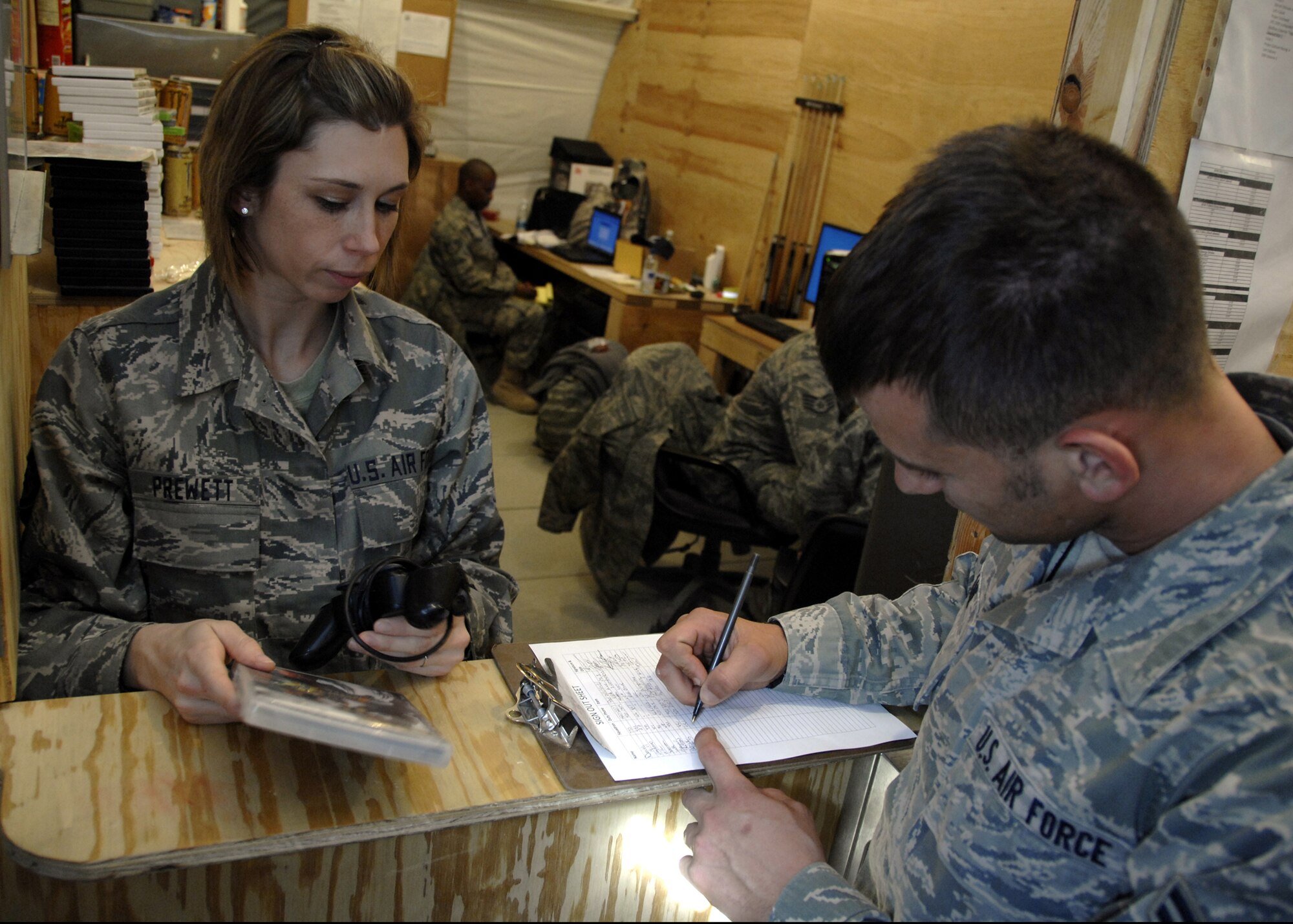Staff Sgt. Kimberly Prewett signs out a video game to an Airman at the Camp Samek Recreation Tent Jan. 10, 2010. Sergeant Prewett is a Recreation and Lodging noncommisioned officer with the 451st EFSF from F.E. Warren Air Force Base, Wy. (U.S. Air Force photo/Senior Airman Timothy Taylor/Released)