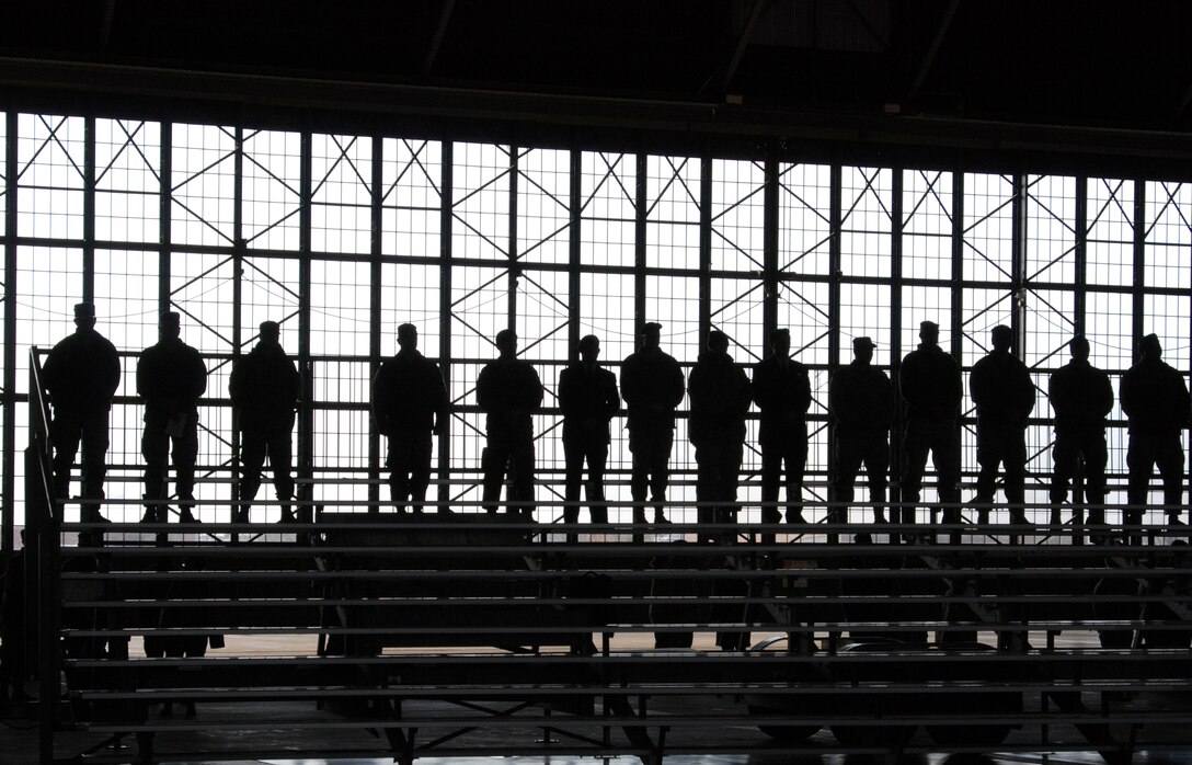 Air Force Reserve Command personnel are silhouetted by the doors of Hangar 1 at Scott Air Force Base. They were waiting their turn to pay tribute to the 932nd Airlift Wing's Tech. Sgt. Anthony C. Campbell, Jr. following a memorial service Jan. 9 at Scott AFB. Sergeant Campbell was killed in action in Afghanistan Dec. 15.  (U.S. Air Force photo/Tech. Sgt. Gerald Sonnenberg)