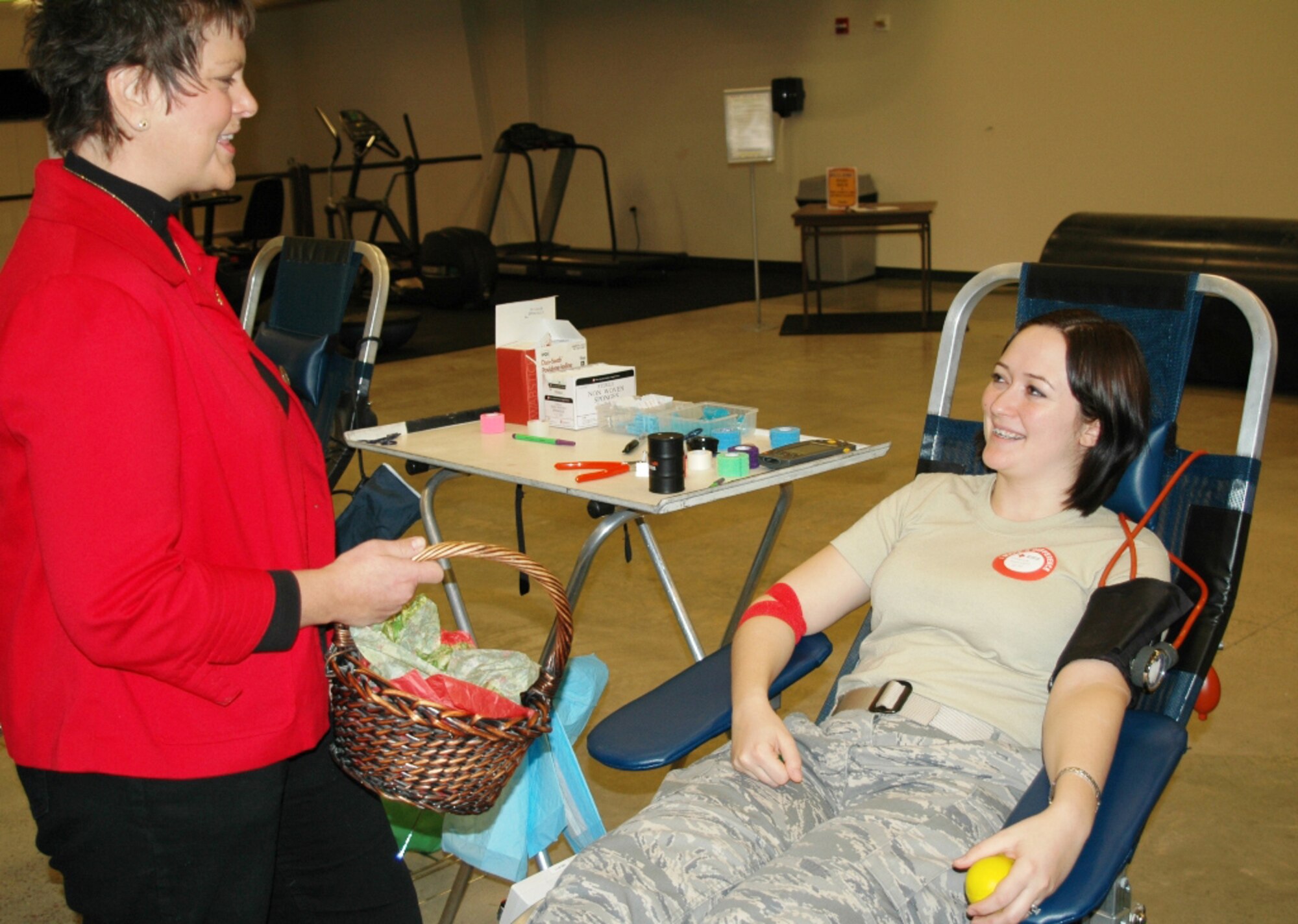 Marilee Stott talks with Airman 1st Class Veronica Hamilton, 341st Medical Operations Squadron, during Malmstrom's blood drive on Dec. 22, 2009. Ms. Stott, a cancer survivor who received more than 200 units of blood during her cancer treatment, came to the base to thank blood donors for their life-saving contributions. (U.S. Air Force photo/Tech. Sgt. Marcus McDonald)