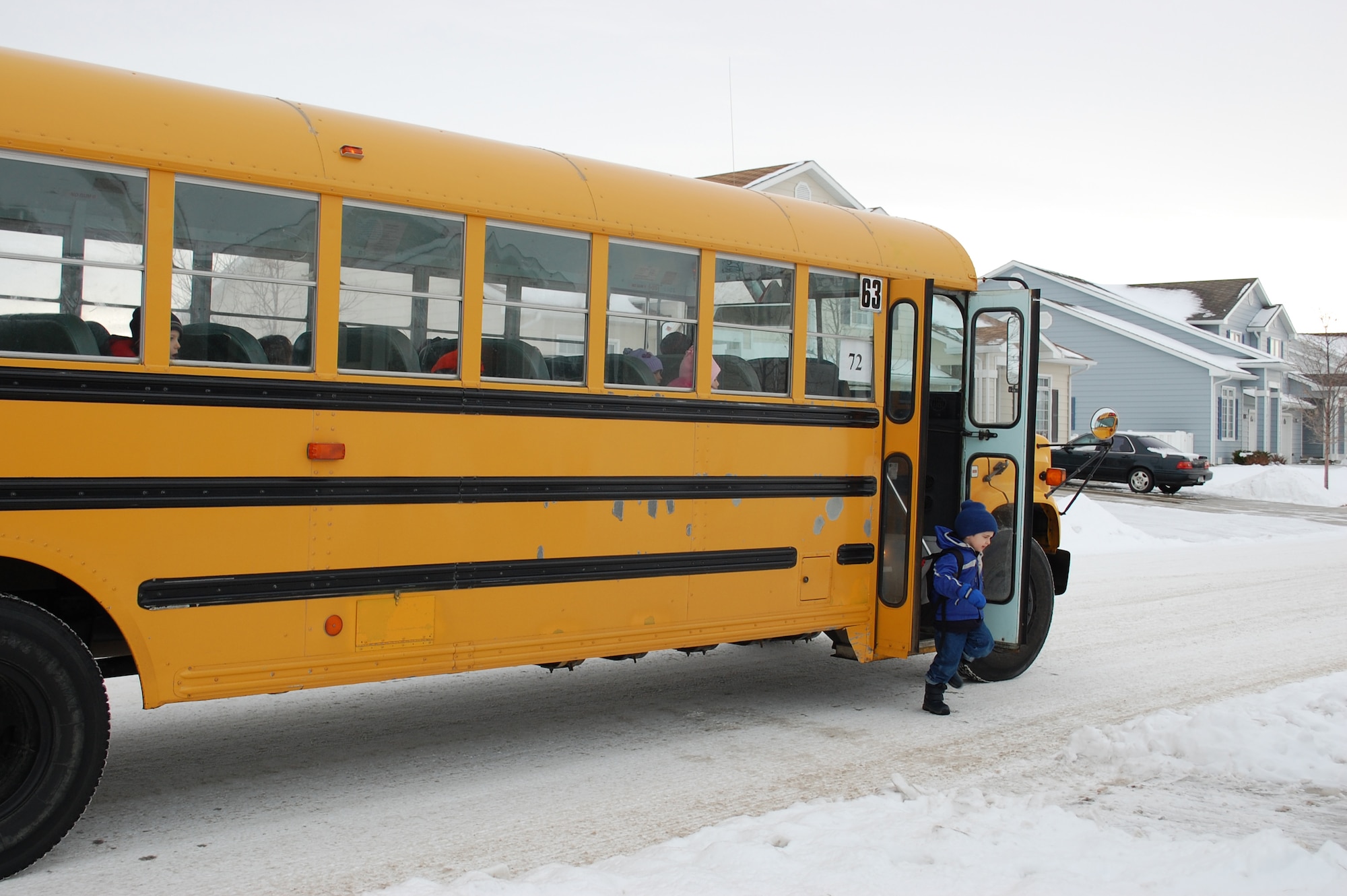A school bus from Big Sky Bus Lines, the contractor with Malmstrom, drops off a student after school in the Matador Manor housing area. Bus routes for North Middle School and C.M. Russell High School will change starting Jan. 11. (U.S. Air Force photo/Valerie Mullett)