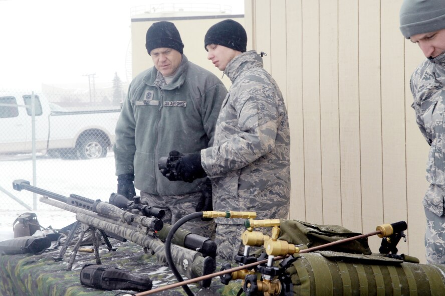 Chief Master Sgt. of the Air Force James Roy is shown weapon equipment Dec. 24, 2009, by Airman First Class Justin Allison from the 91st Missile Security Forces Squadron at Minot Air Force Base, N.D. Chief Roy spent the Christmas holiday there and used the opportunity to meet Airmen from both the 5th Bomb Wing and the 91st Missile Wing and tell them their work in the nuclear enterprise is critical and that the Air Force is committed to their development. (U.S. Air Force photo/Senior Airman Jesse Lopez)